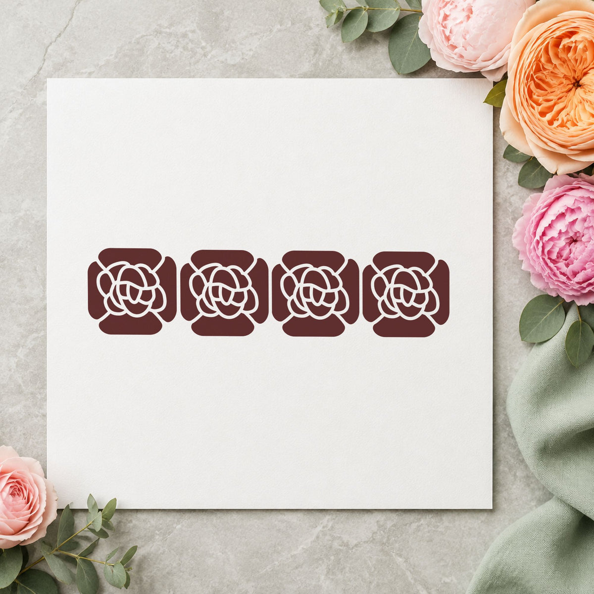 Four Solid Flowers Border Rubber Stamp impression in brown ink on white paper in a styled craft setting.