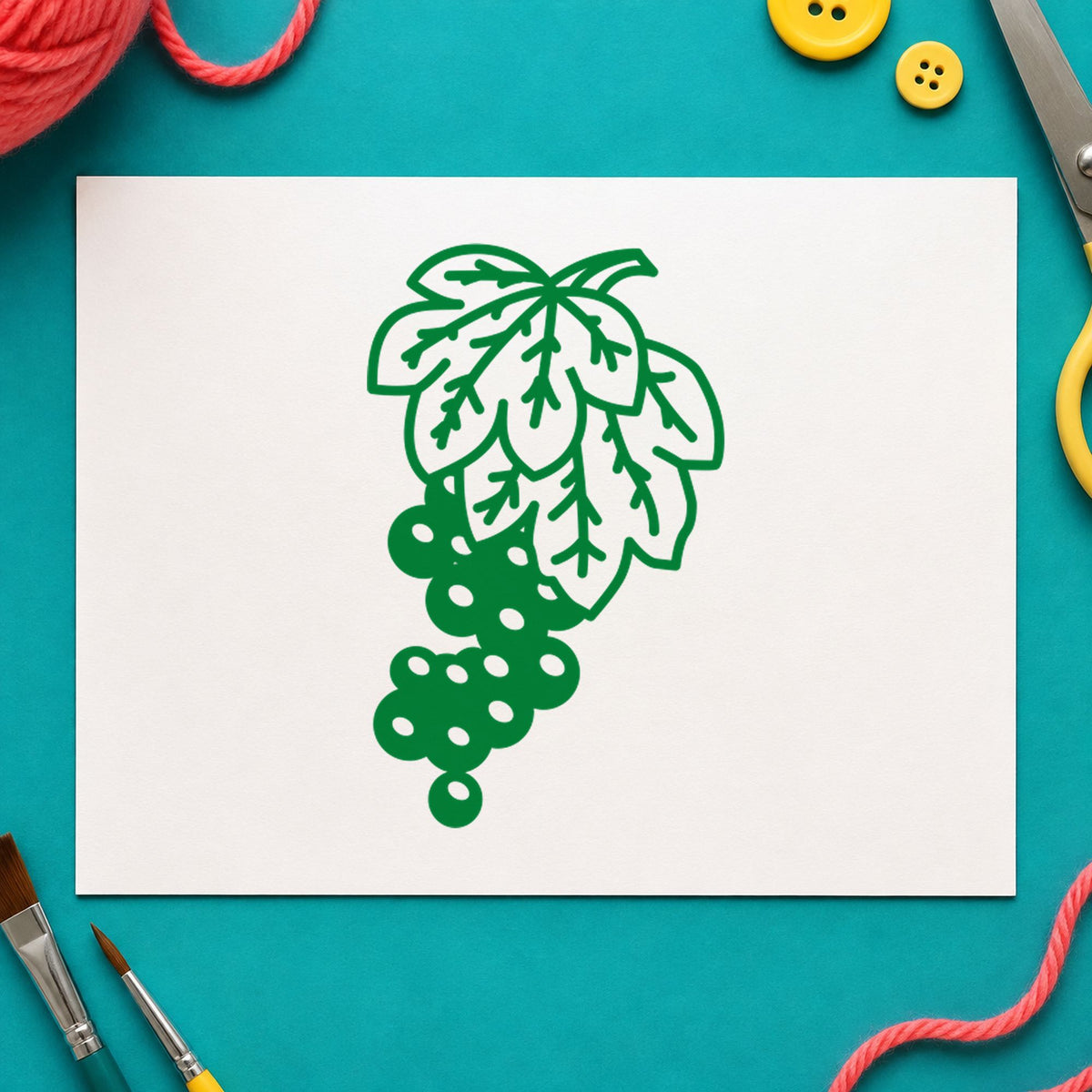 Grape Bunch on Vine Rubber Stamp impression in green ink on white paper in a styled craft setting.