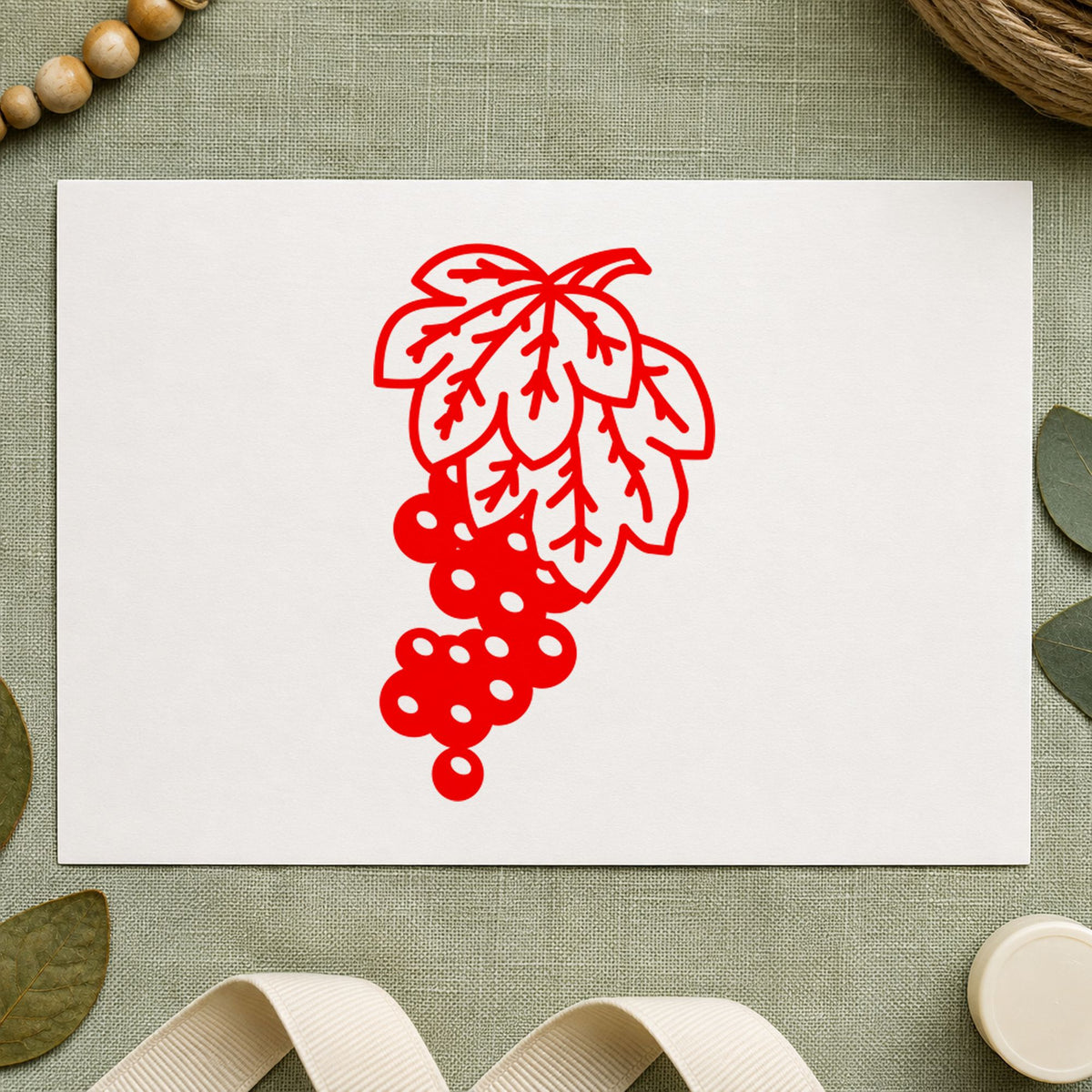 Grape Bunch on Vine Rubber Stamp impression in red ink on white paper in a styled craft setting.