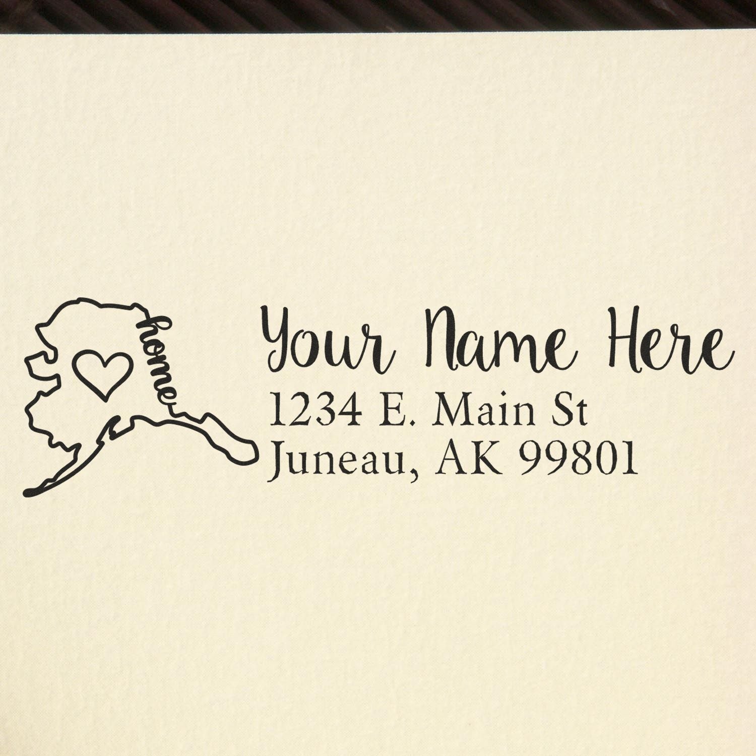 Custom Alaska return address rubber stamp with home icon, heart, and personalized name and Juneau, AK 99801 address.