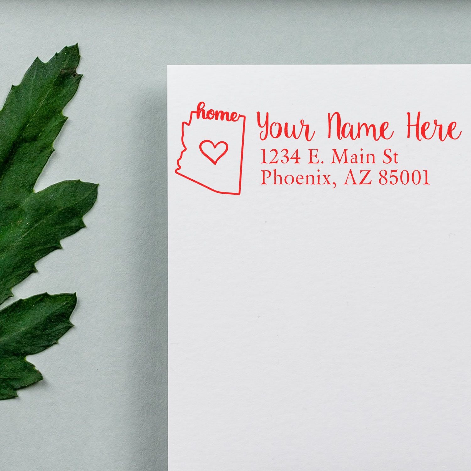 Custom Arizona return address rubber stamp with heart, personalized name, and Phoenix mailing address in red ink on paper.