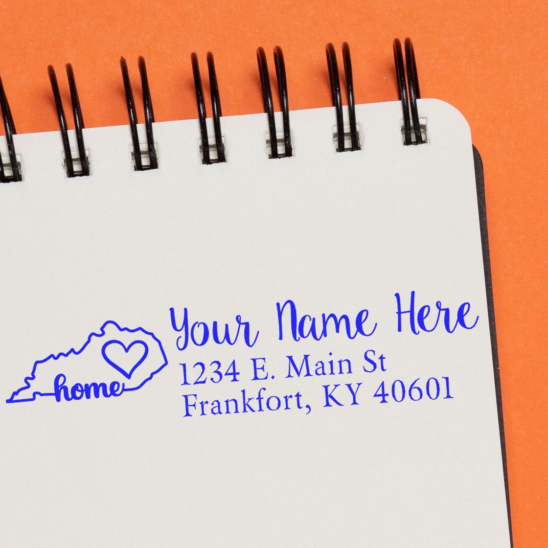 Custom Kentucky home return address rubber stamp with name and address, shown in blue ink on notebook paper.