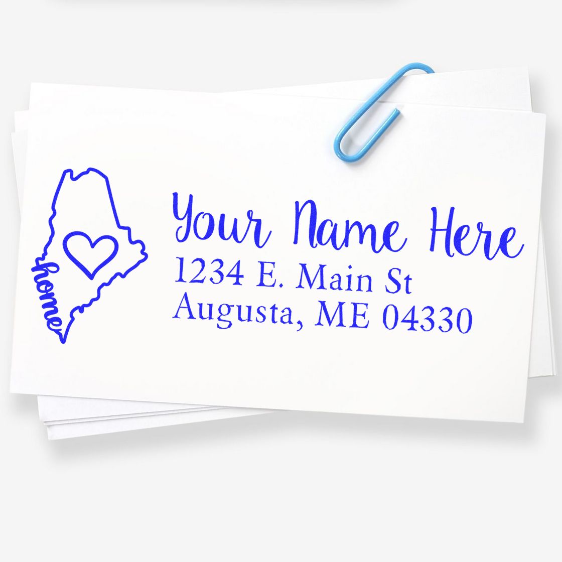 Custom return address rubber stamp with Maine state heart design and blue name and address imprint on envelopes
