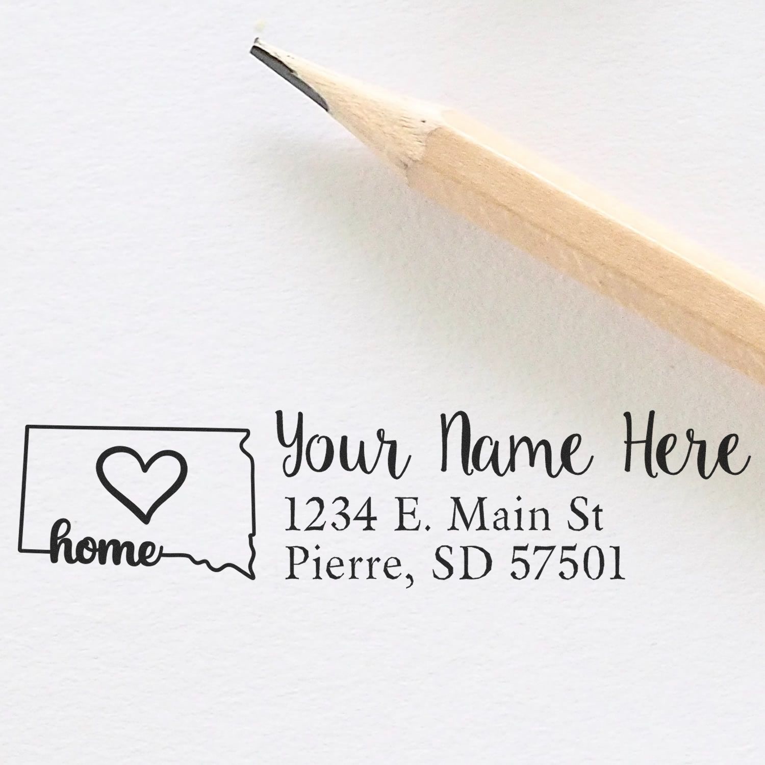 Custom return address rubber stamp with South Dakota home design and pencil previewing personalized name and address.