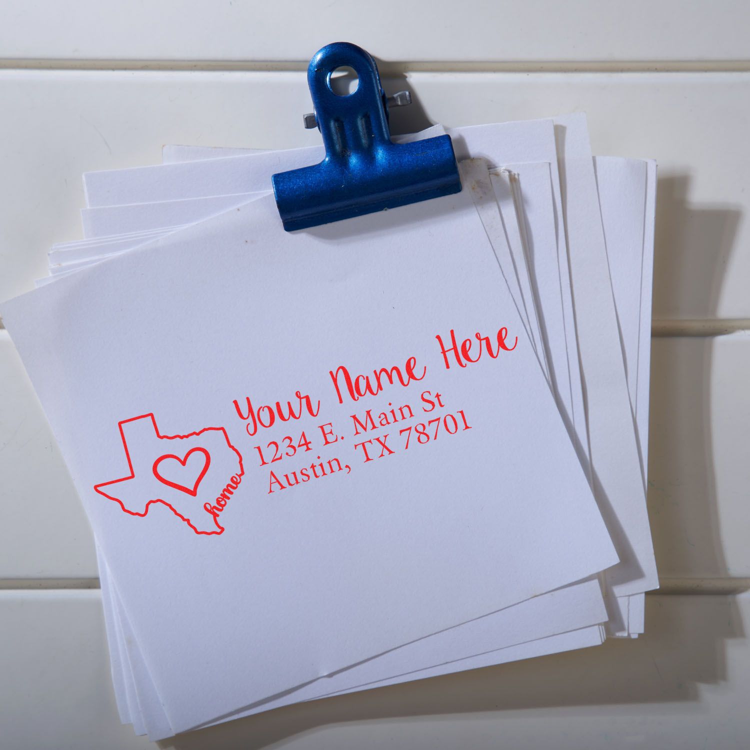 Custom Texas return address rubber stamp with heart logo, used on envelopes for Austin, TX home mailings.
