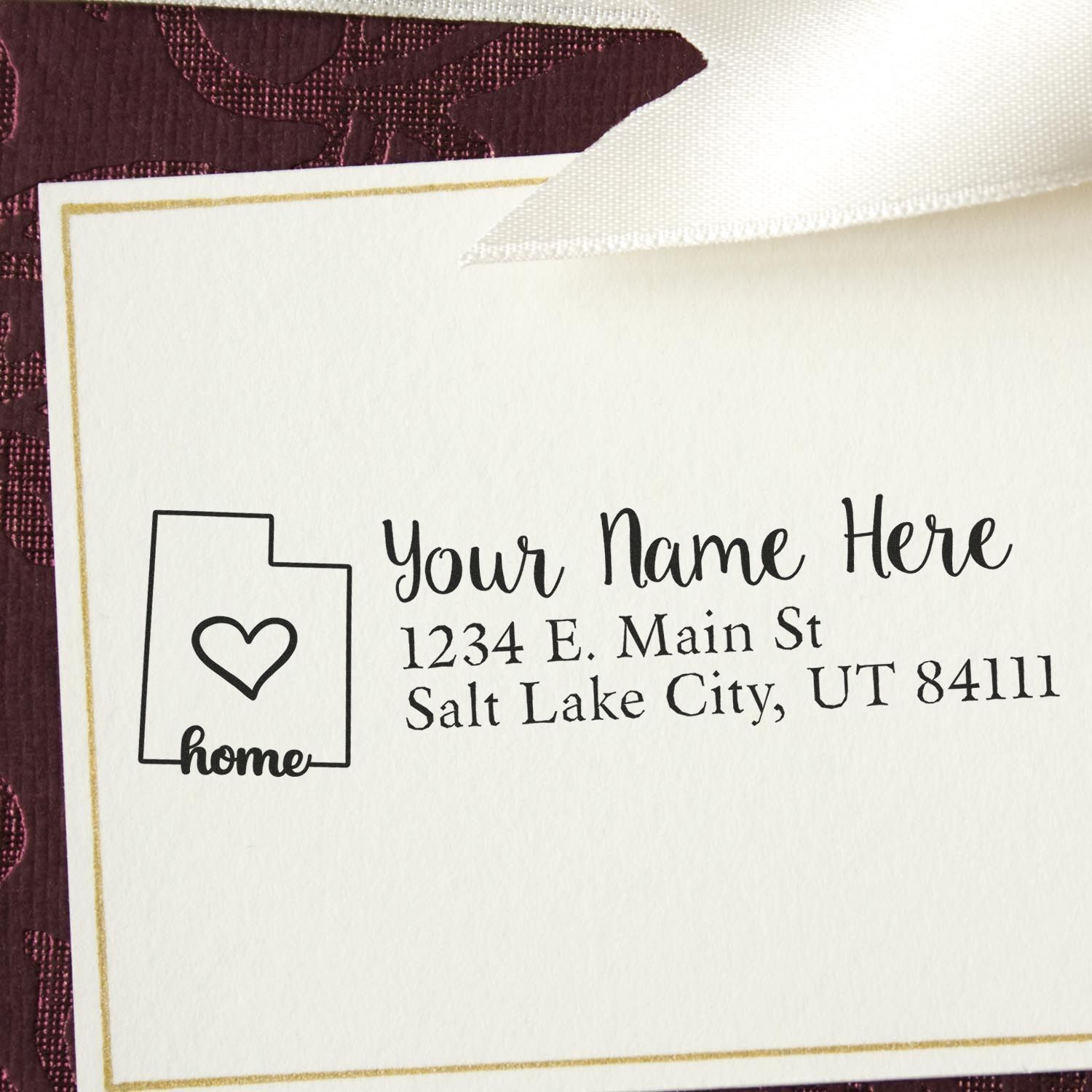 Custom home return address rubber stamp with personalized name, address, and heart house icon on stationery.