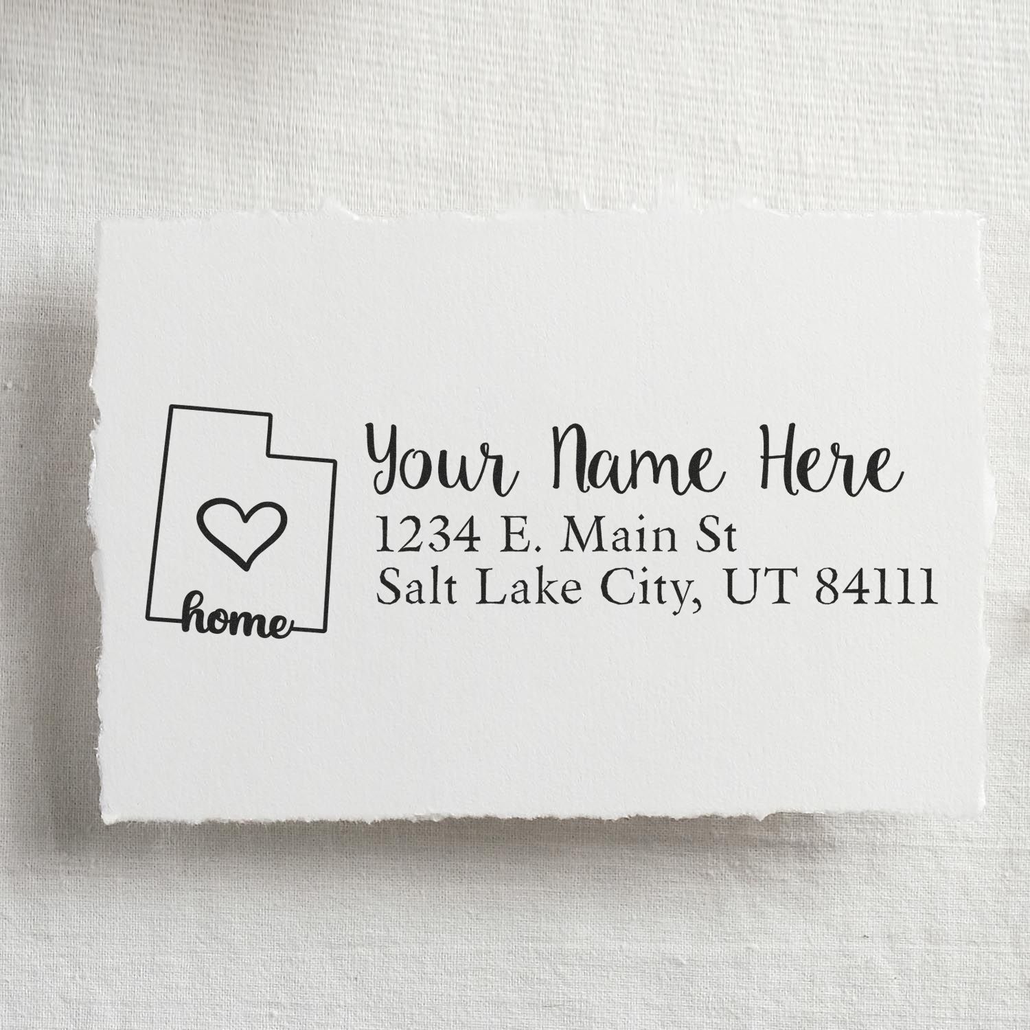Custom home address rubber stamp with state outline and heart for personalized return address labeling on envelopes and stationery.