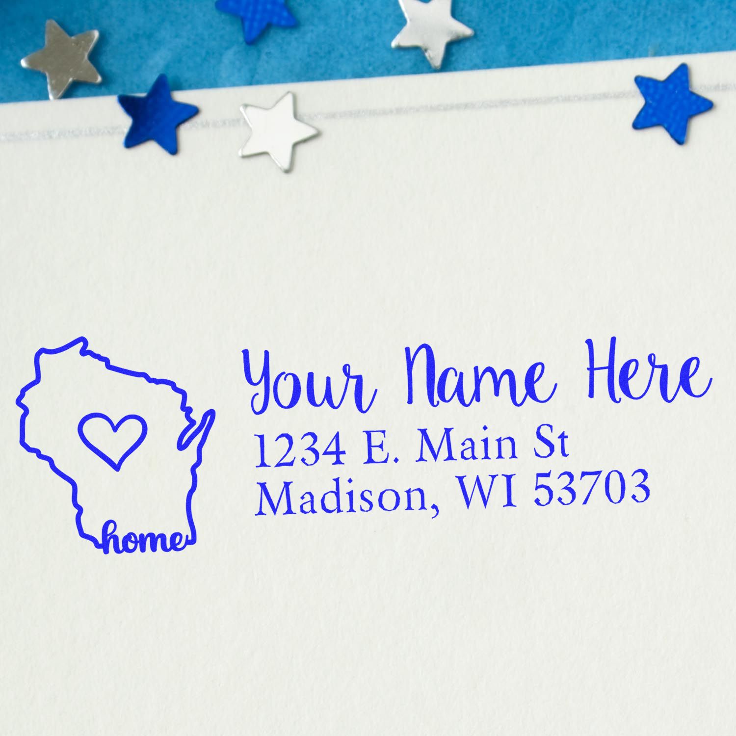 Custom home address rubber stamp featuring Wisconsin outline and heart, printed in blue ink with personalized name and address.