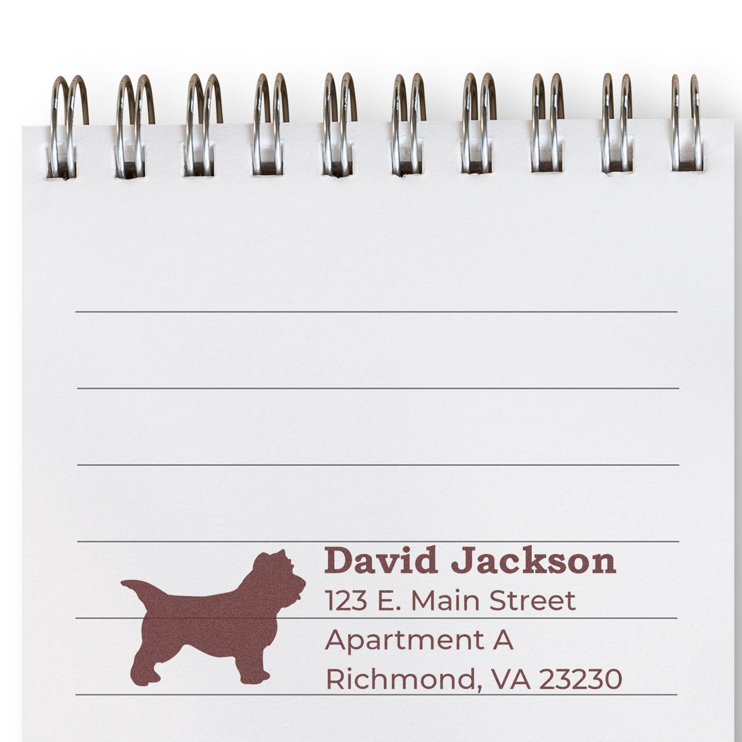 Custom rubber stamp design with dog silhouette and return address on spiral notebook page