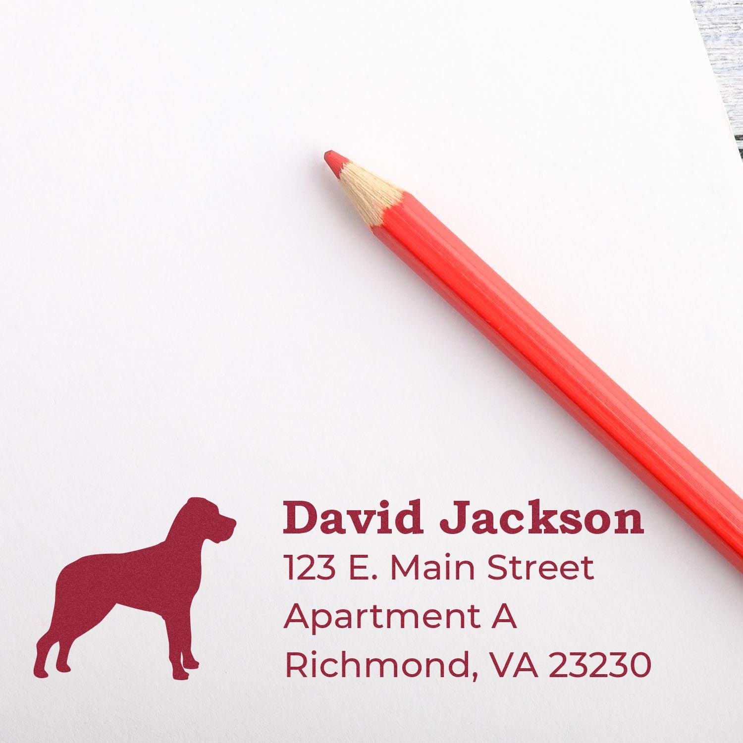 Personalized dog address rubber stamp with name and Richmond, VA return address on paper beside a red pencil.