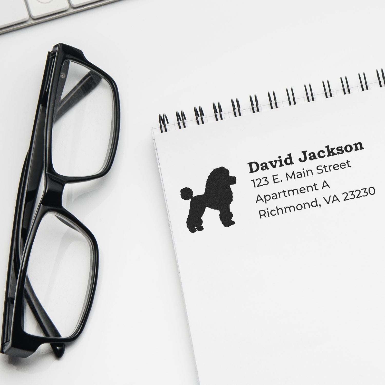 Custom rubber return address stamp with poodle silhouette for personalized mail and stationery.