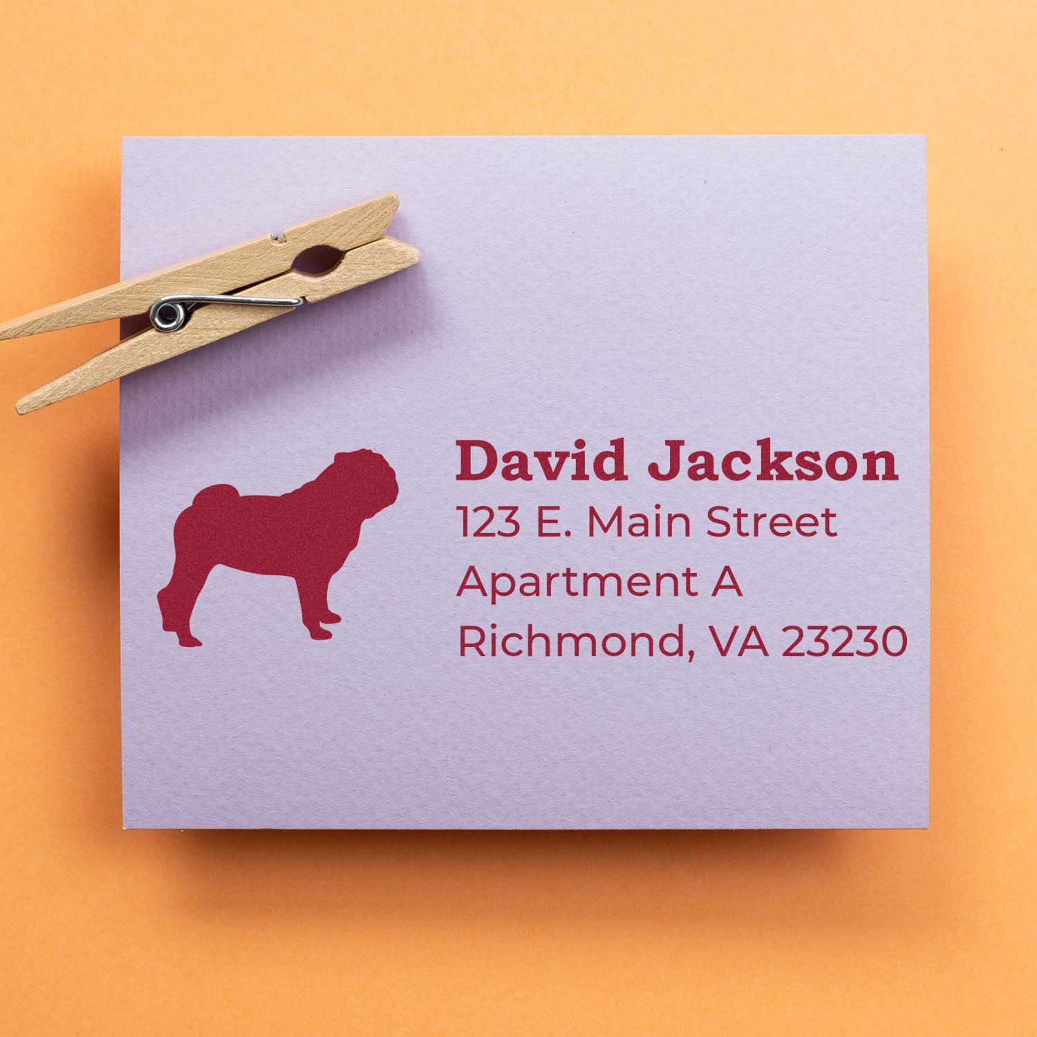 Personalized rubber return address stamp with dog silhouette on a lavender envelope, clipped with a wooden clothespin.
