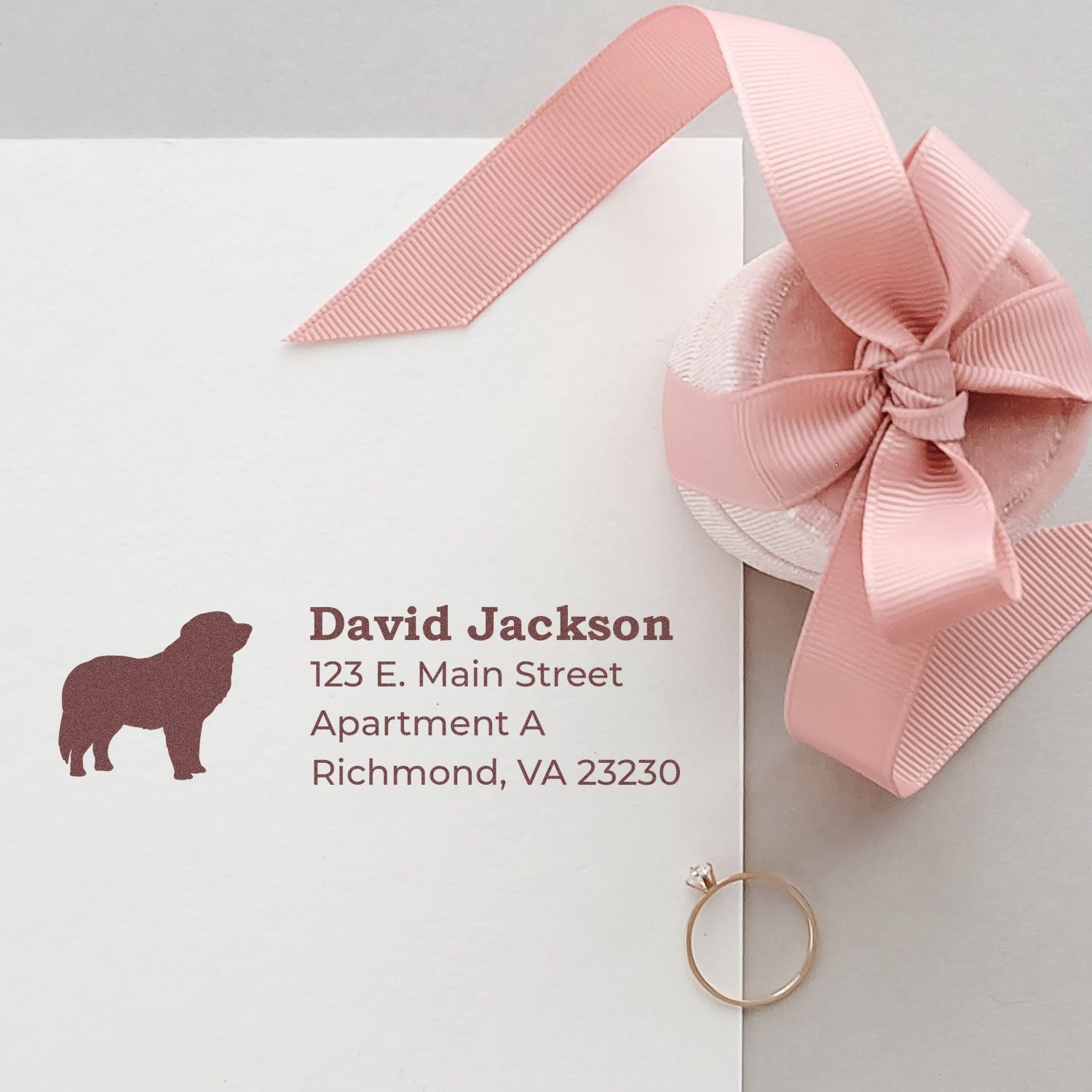Custom personalized return address rubber stamp with dog silhouette on white envelope and pink ribbon gift.