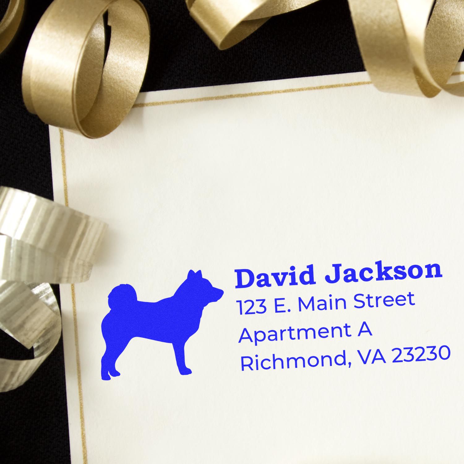 Custom rubber return address stamp with dog silhouette on elegant envelope, blue ink, and gold ribbon.
