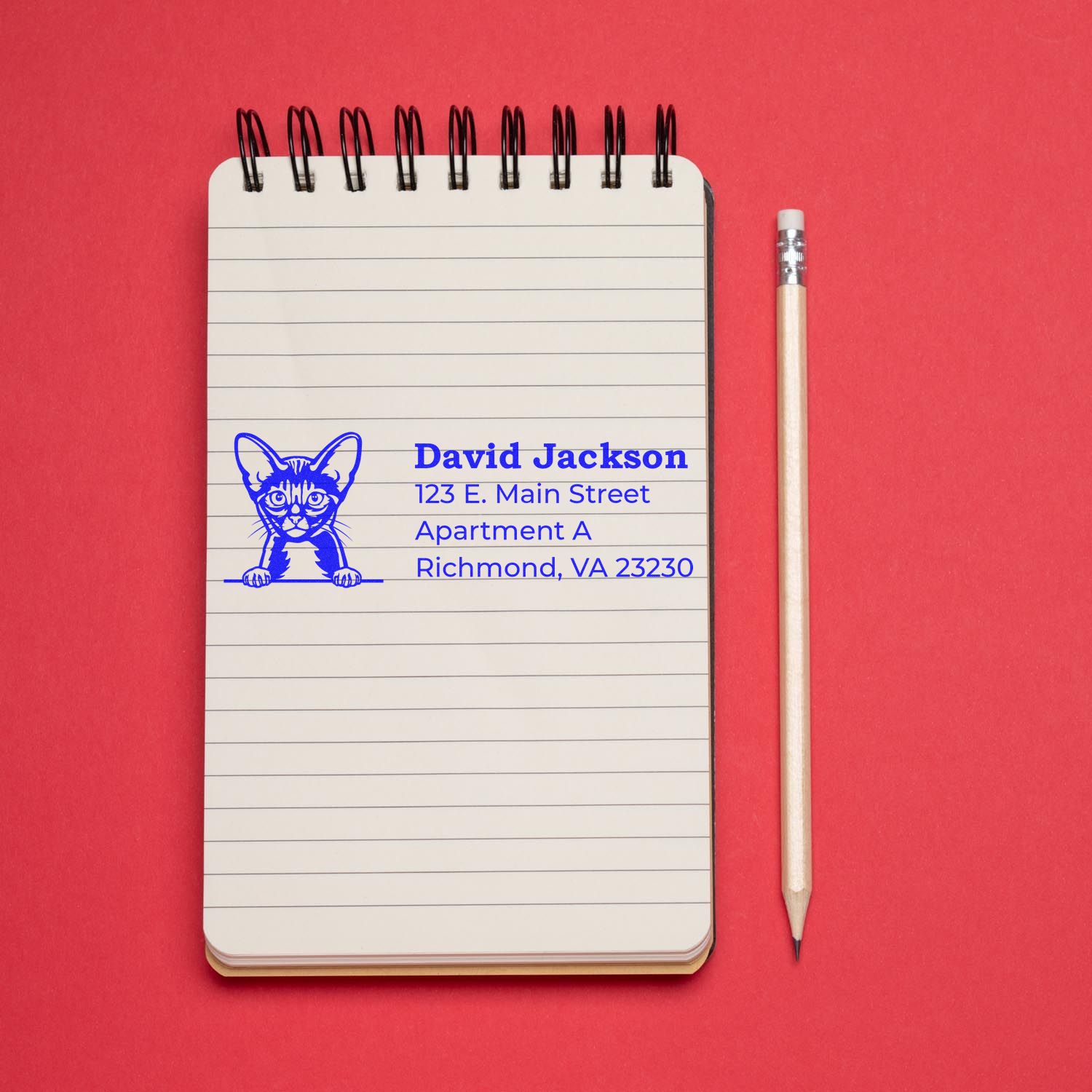 Custom return address rubber stamp with cat design on notebook, ideal for personalized stationery and mailing.
