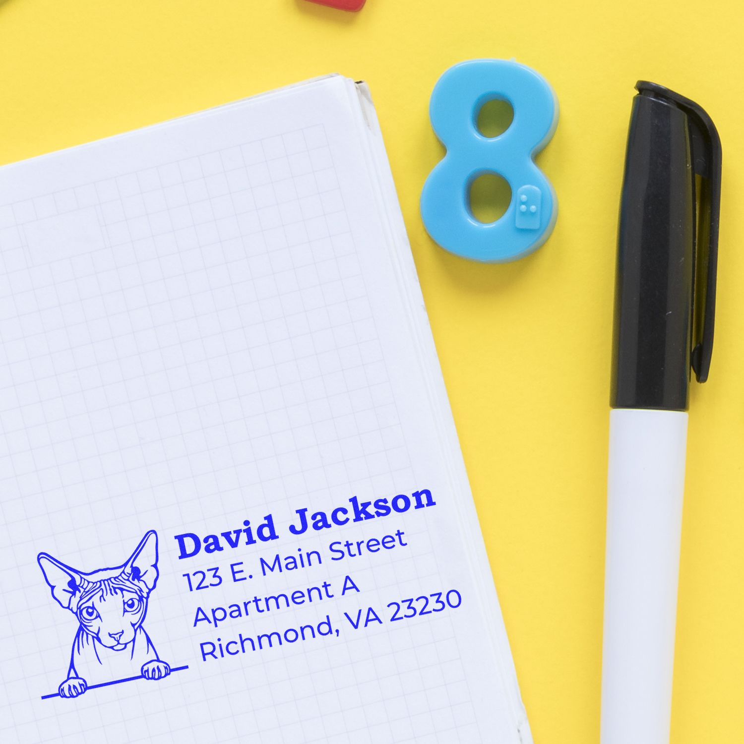 Custom address rubber stamp with cat illustration on notebook, ideal for personalized mailing and pet lover branding.