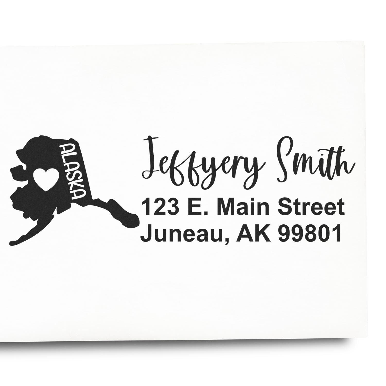 Personalized Alaska address rubber stamp with state silhouette, heart icon, and Jeffery Smith return address in Juneau, AK.