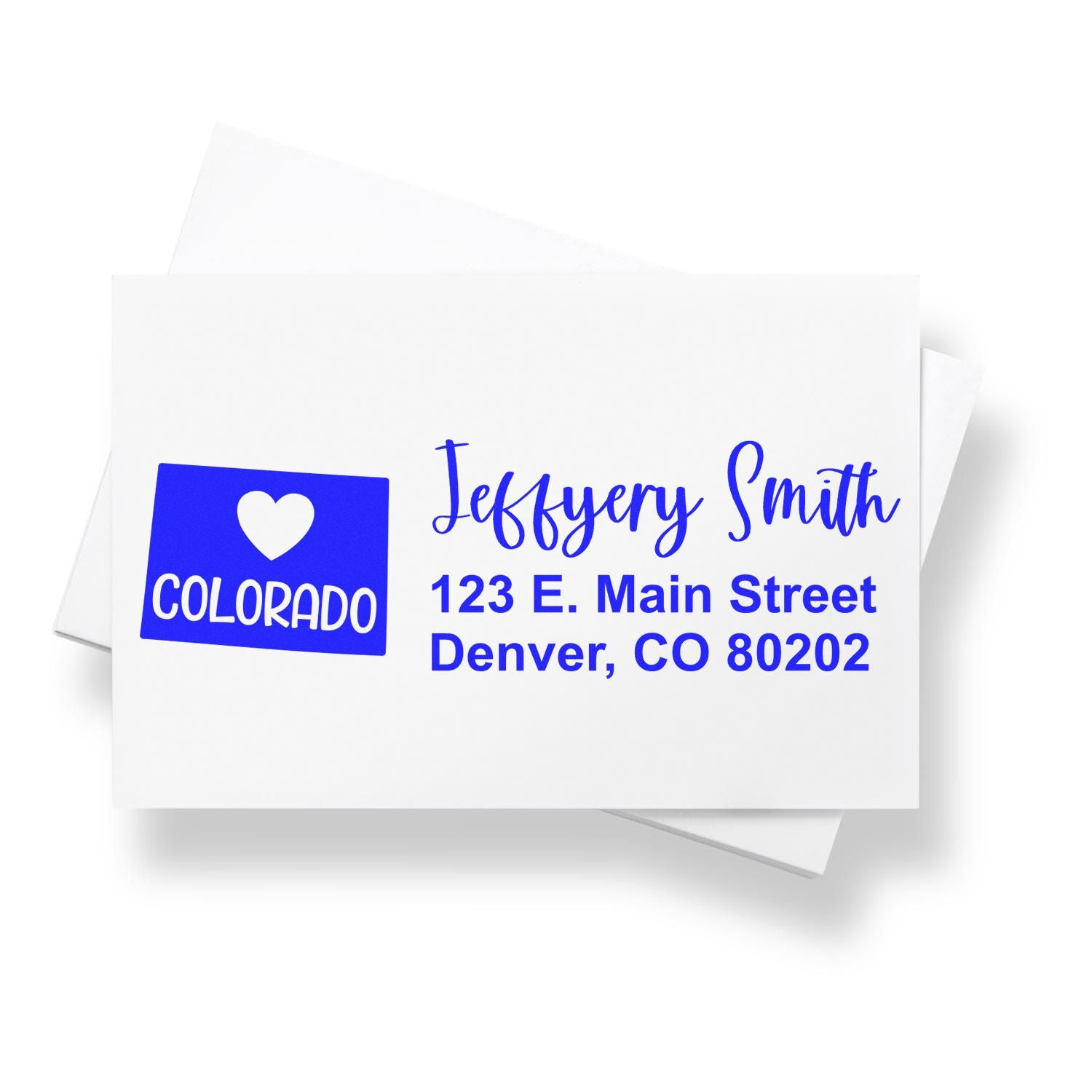 Custom return address rubber stamp with Colorado heart logo, name, and Denver address for mailing envelopes.