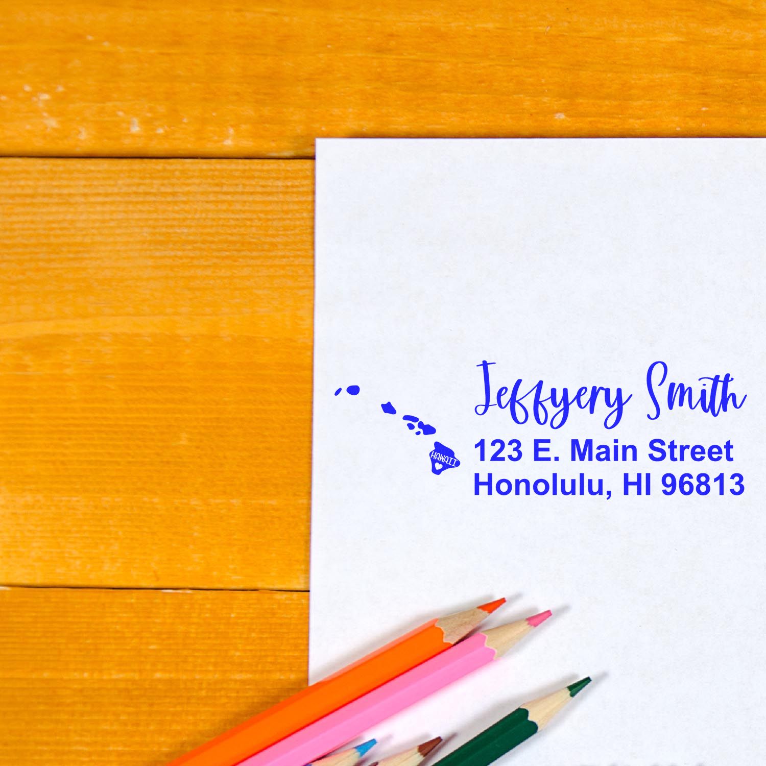 Custom Hawaii return address rubber stamp on envelope with island map and blue address imprint.