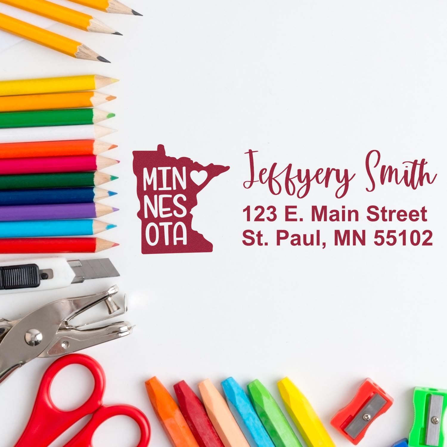 Personalized Minnesota return address rubber stamp with name and address, shown with colorful school and craft supplies.