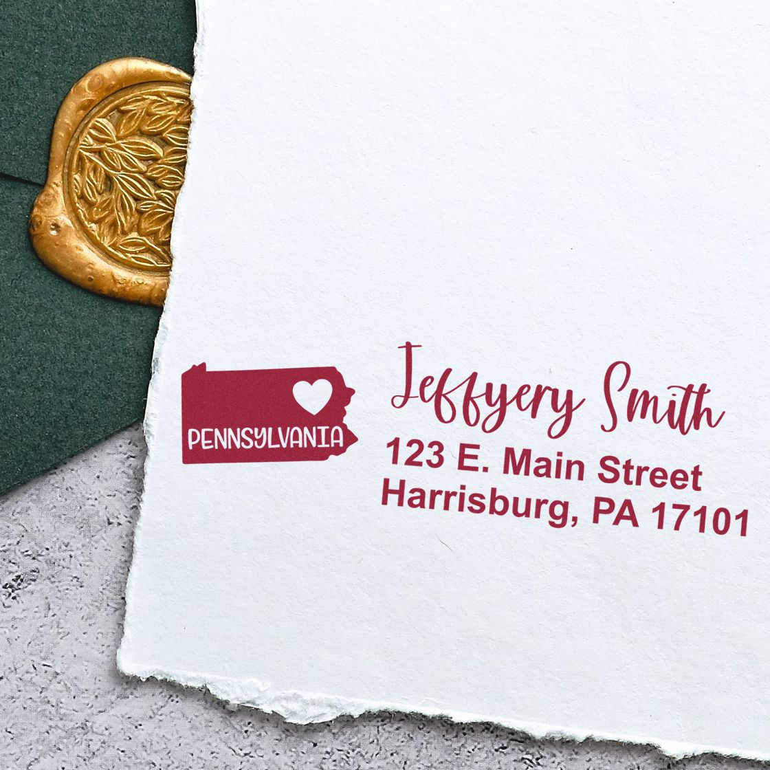 Custom rubber stamp with Pennsylvania return address, name, and Harrisburg, PA address on white paper.