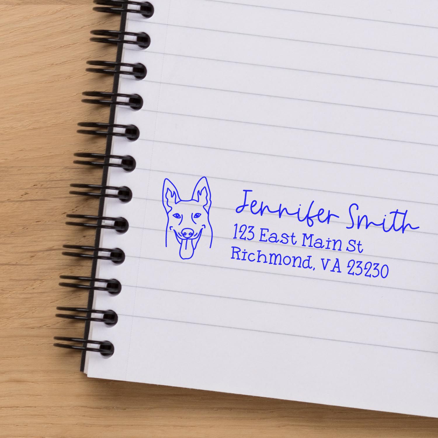 Custom return address rubber stamp with dog logo on notebook page, featuring name and Richmond, VA address.