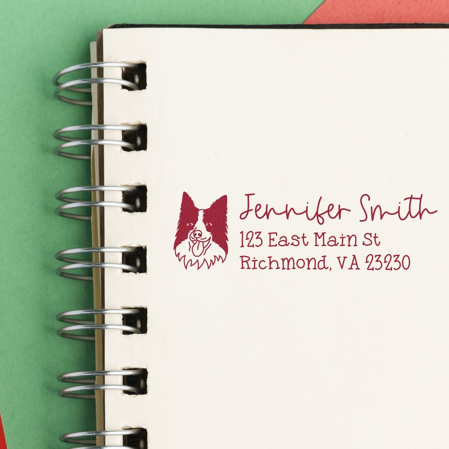 Personalized return address rubber stamp with dog logo, name, and address on notebook page.