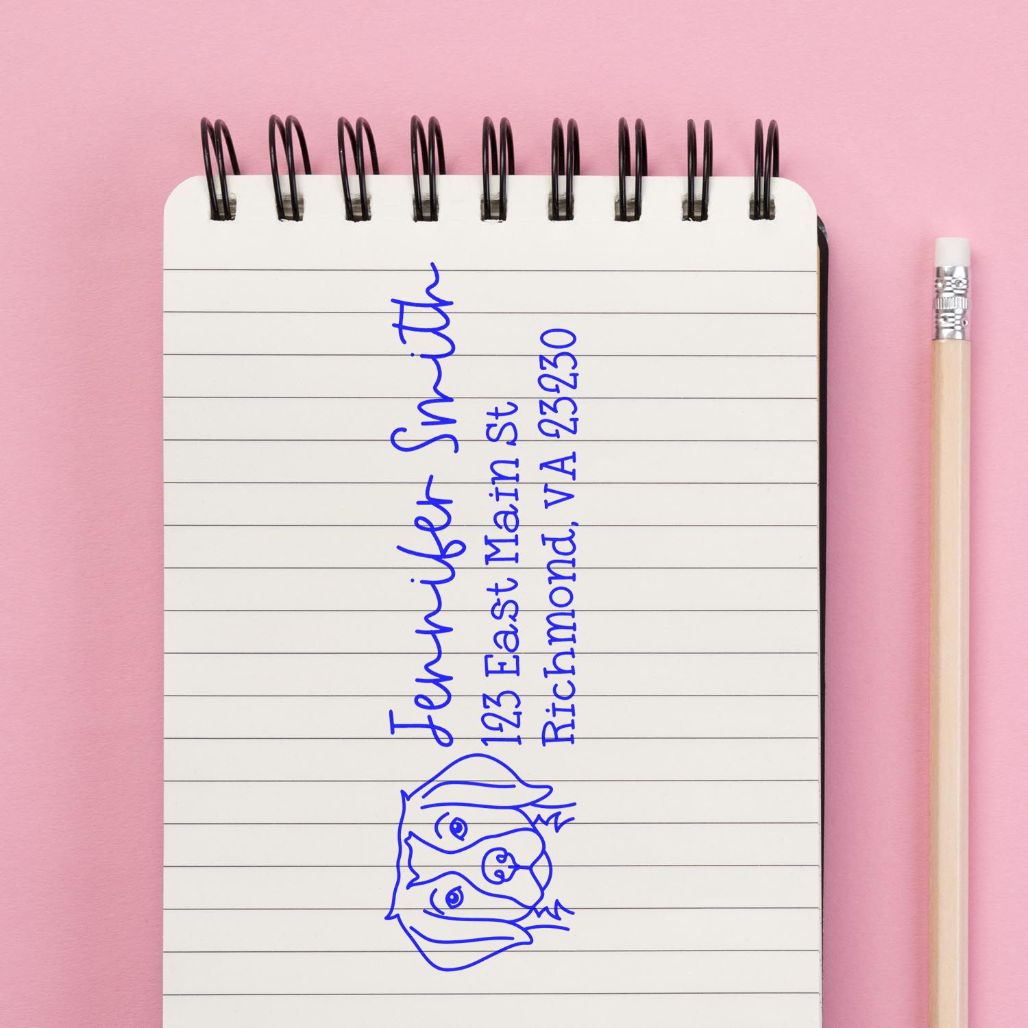 Custom address rubber stamp imprint with dog logo and Jennifer Smith Richmond, VA return address on notebook.