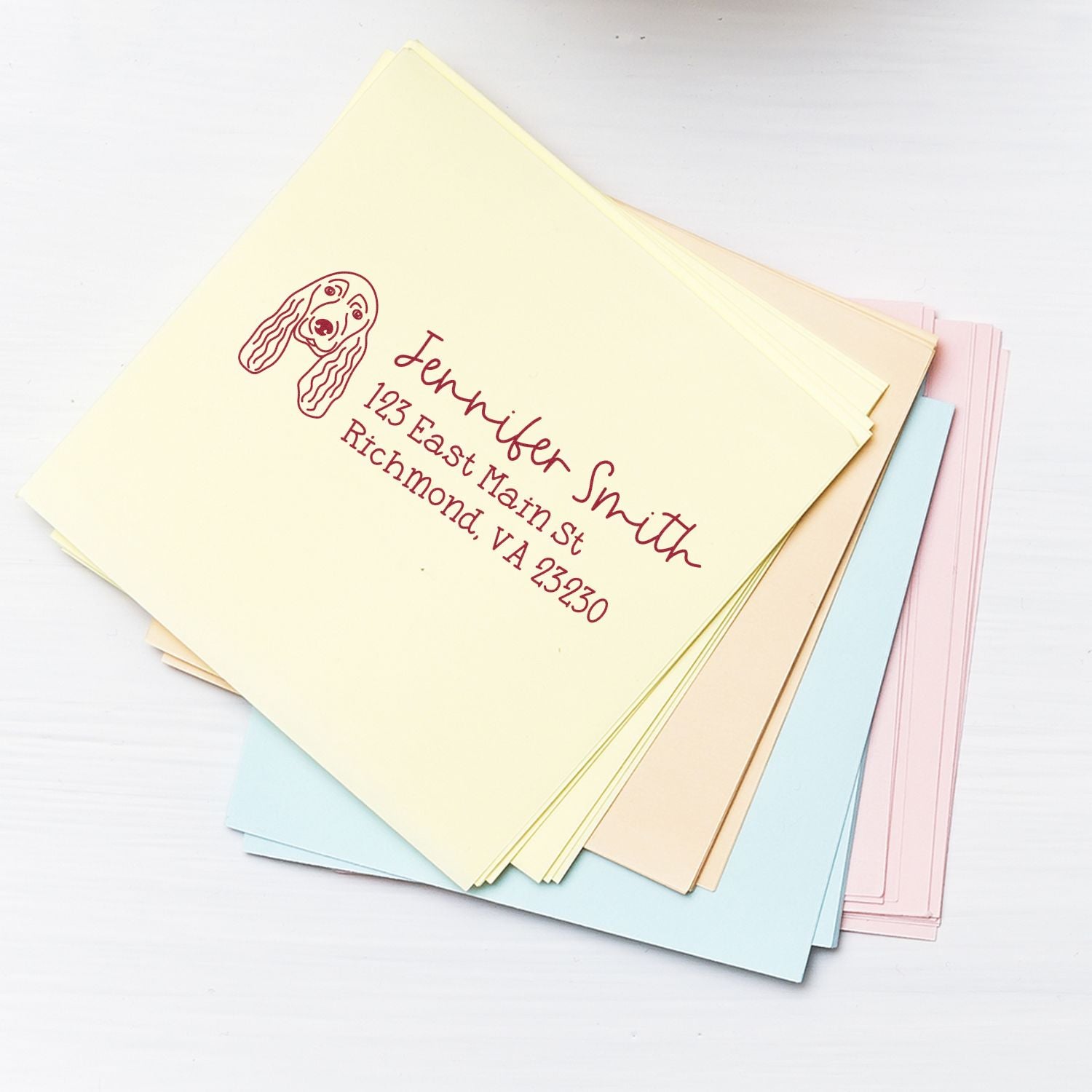 Custom rubber return address stamp with dog icon on pastel envelopes for personalized wedding invitations and mail