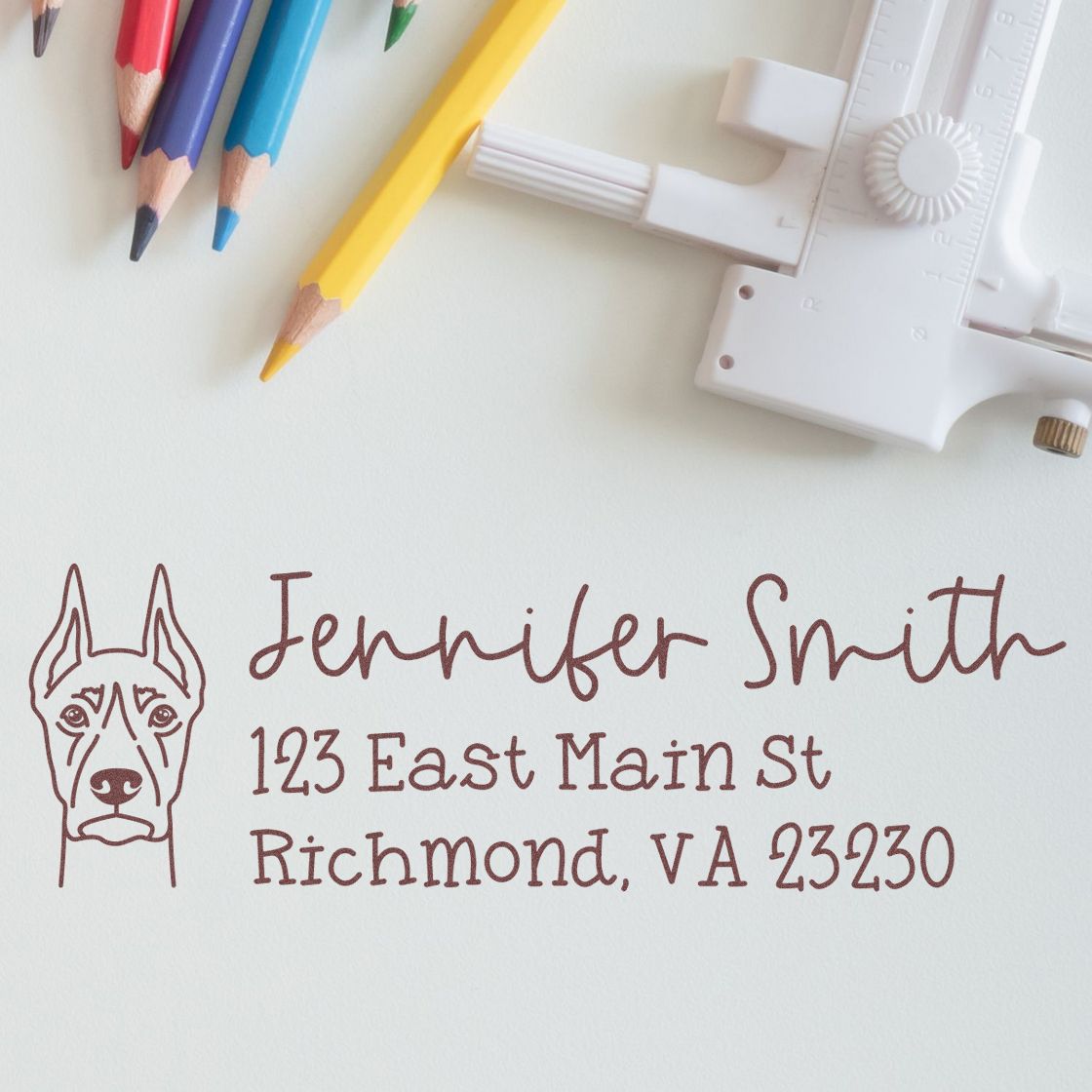 Custom dog return address rubber stamp with name, street, and Richmond, VA address, shown with colored pencils and stamp tool.