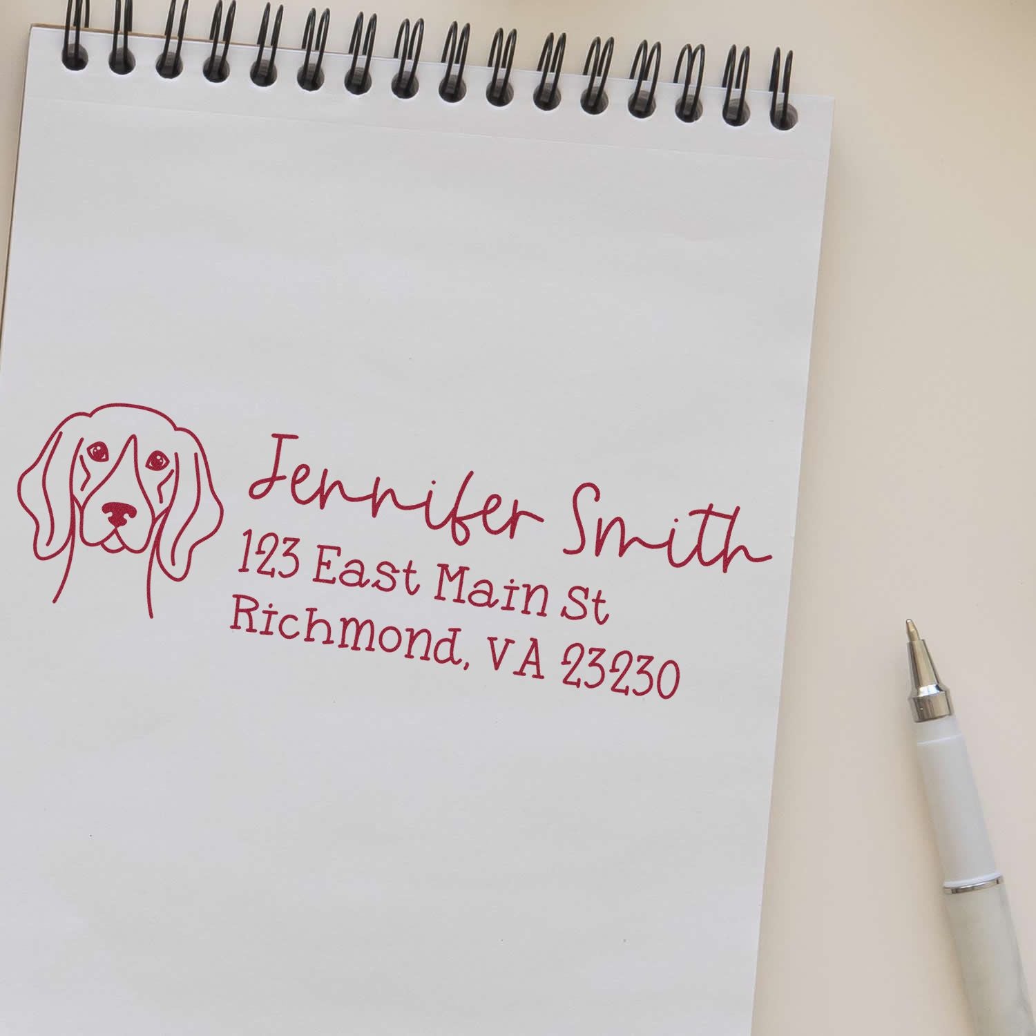 Custom rubber address stamp with dog illustration, showing Jennifer Smith return address on notebook paper.