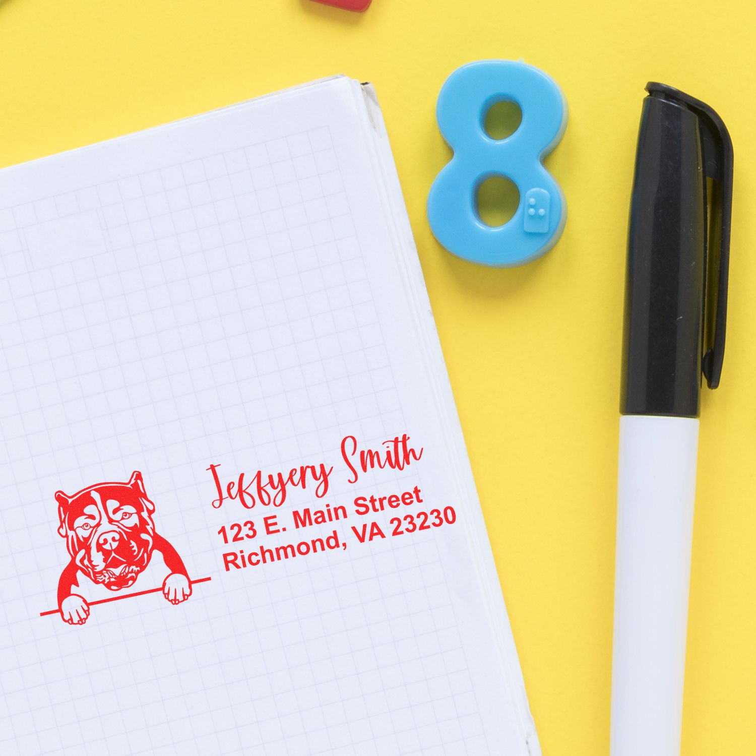 Custom rubber address stamp with dog logo on notebook, ideal for personalized business or pet-themed mailing.