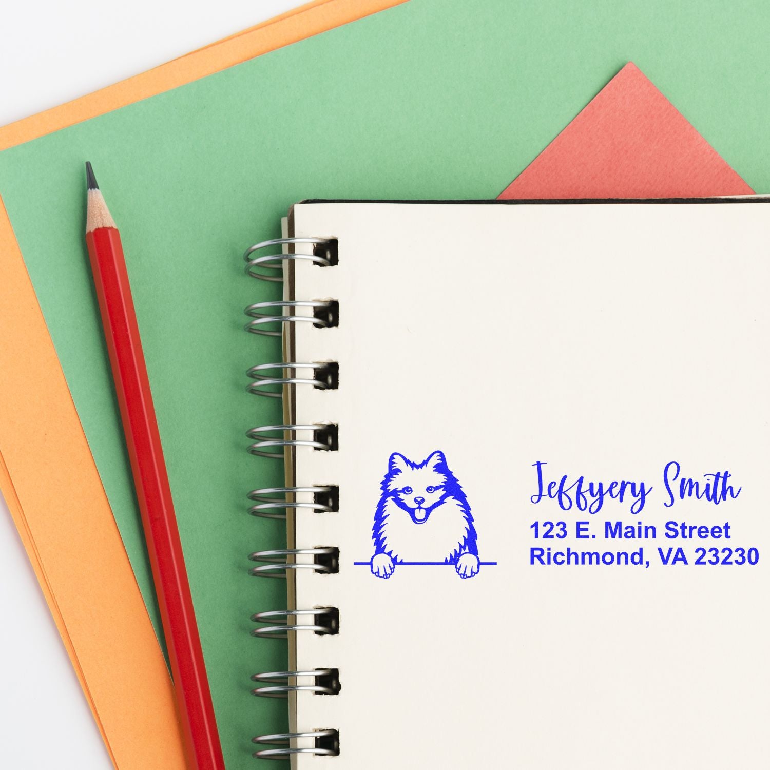 Custom rubber address stamp with dog logo printed on a notebook, featuring name and Richmond, VA address.