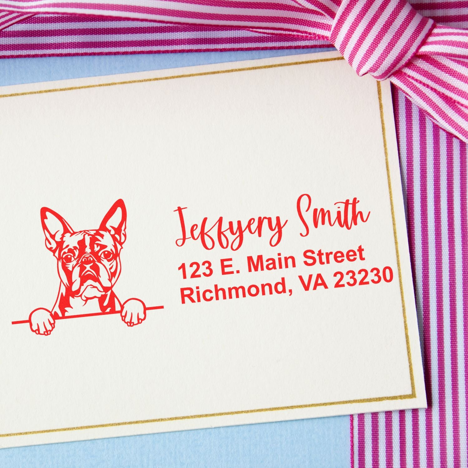 Custom rubber stamp with French bulldog design and personalized return address in red ink on a folded note card.