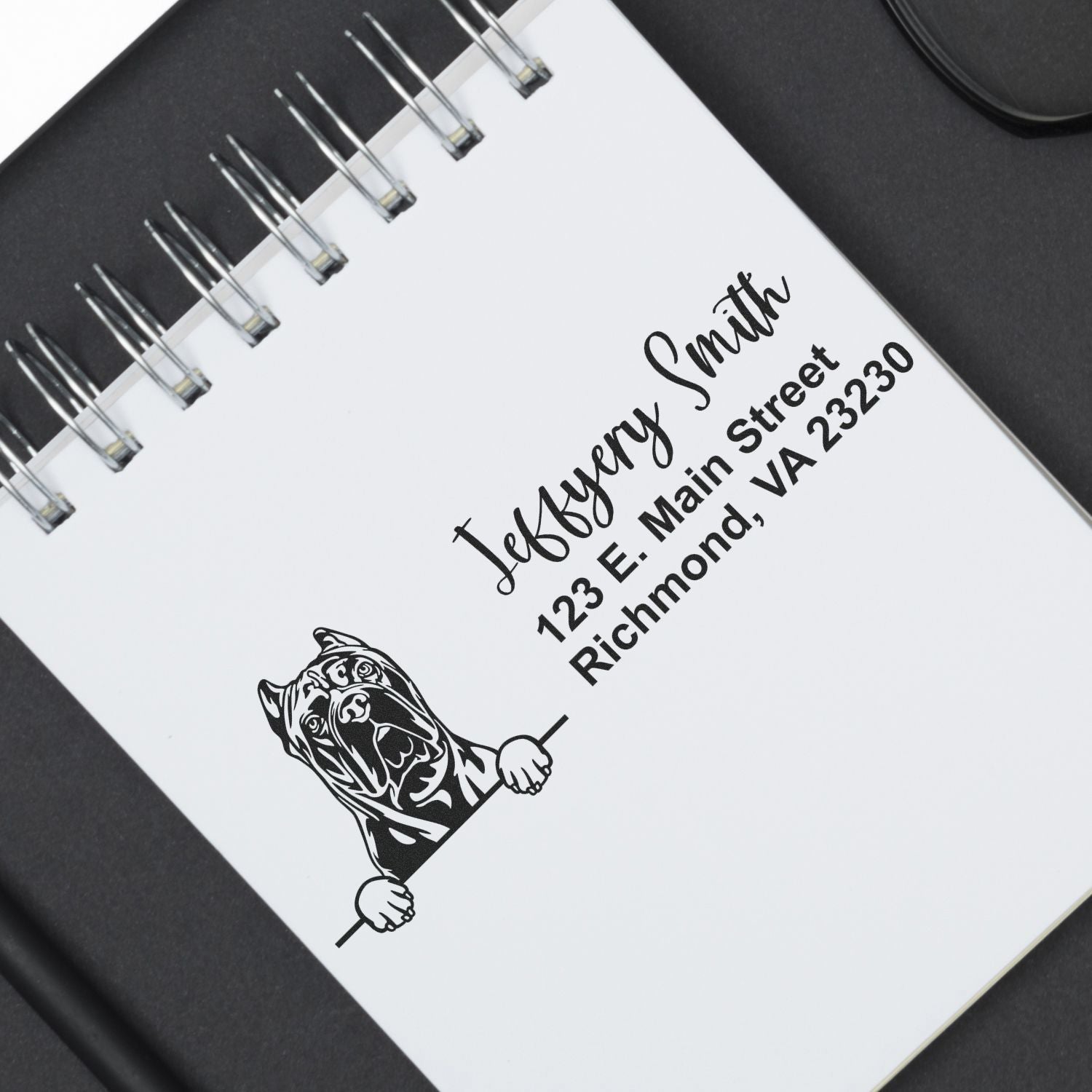Custom return address rubber stamp with name, address, and dog logo on spiral notebook for personalized branding