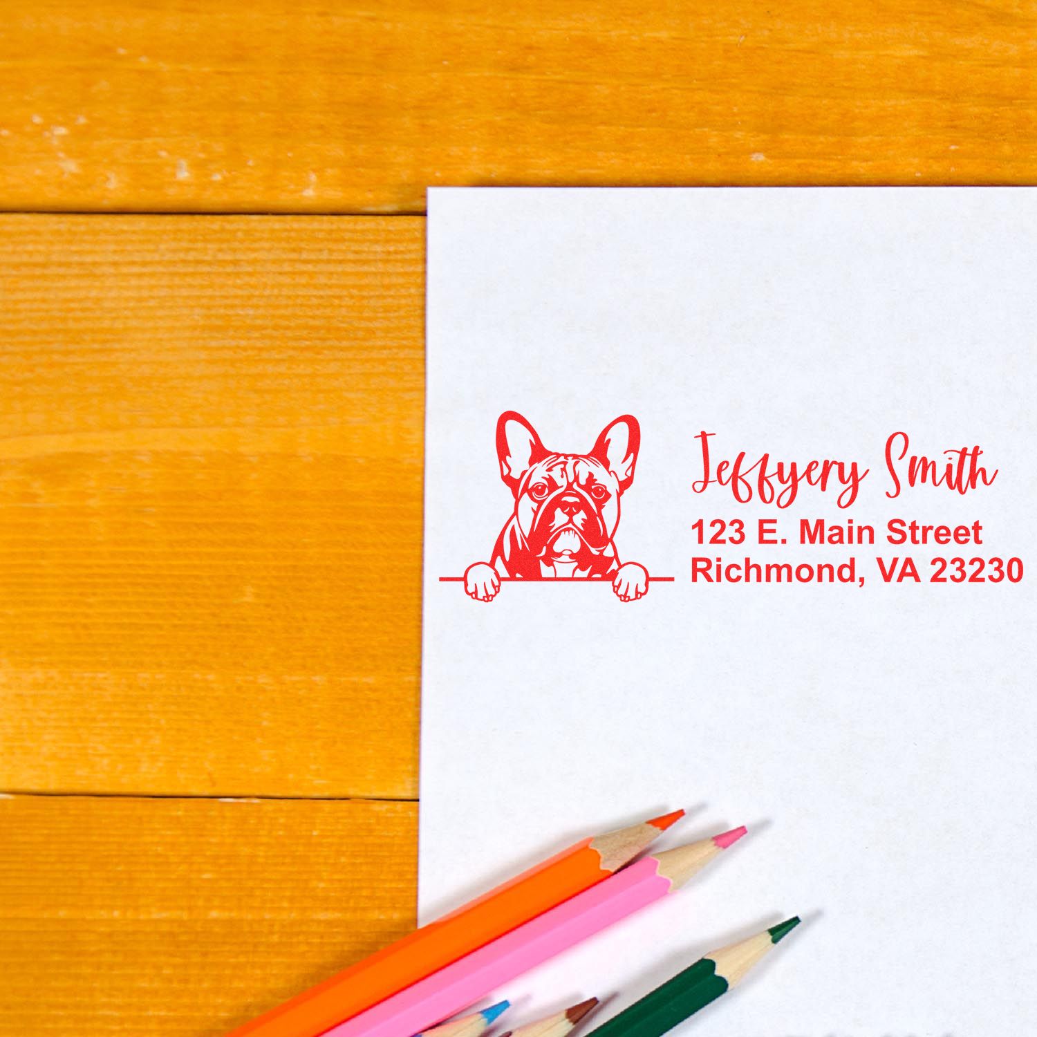 Custom rubber address stamp with French bulldog logo, name, and Richmond, VA return address on paper.