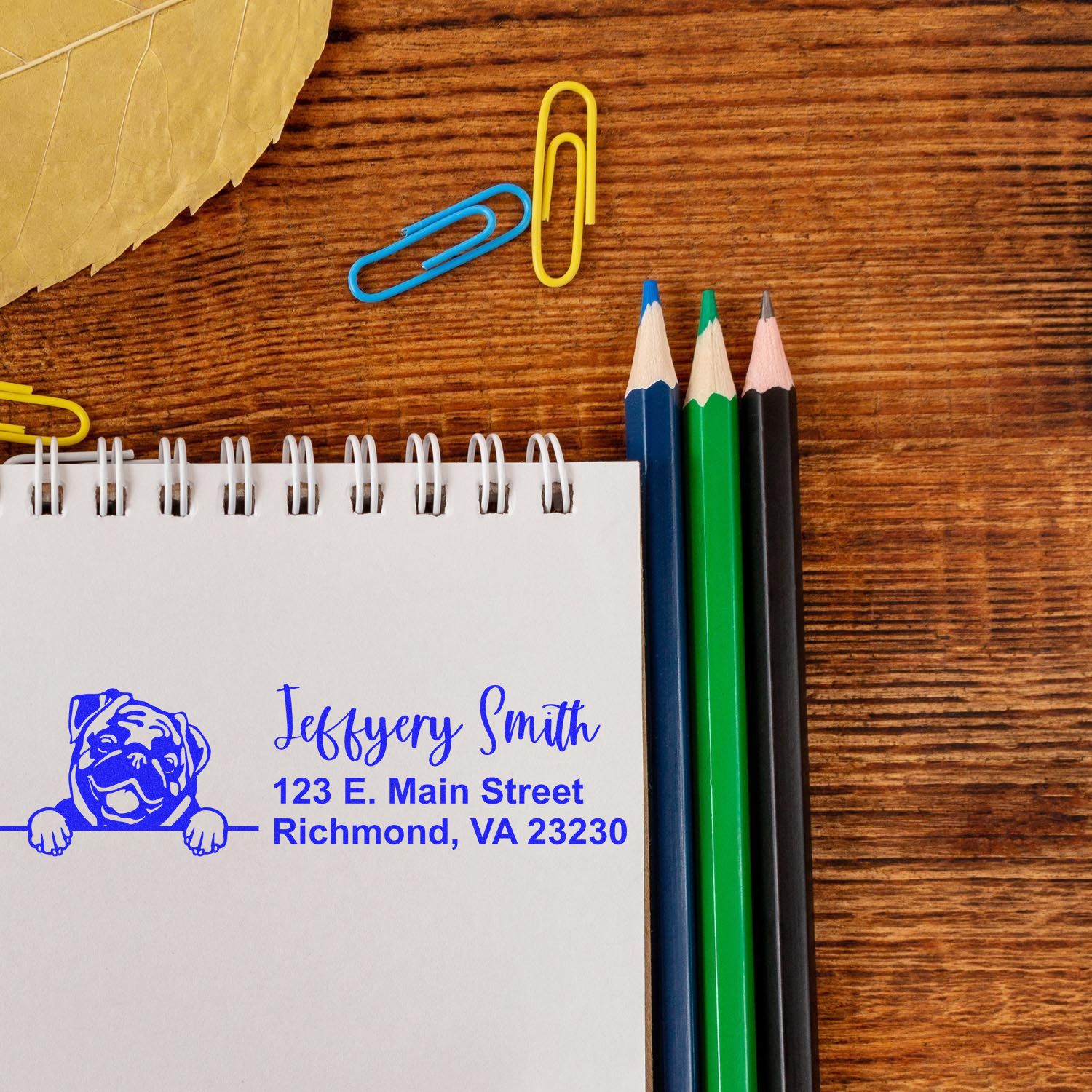 Custom rubber return address stamp with dog logo on notebook, ideal for personalized stationery and business mailing.