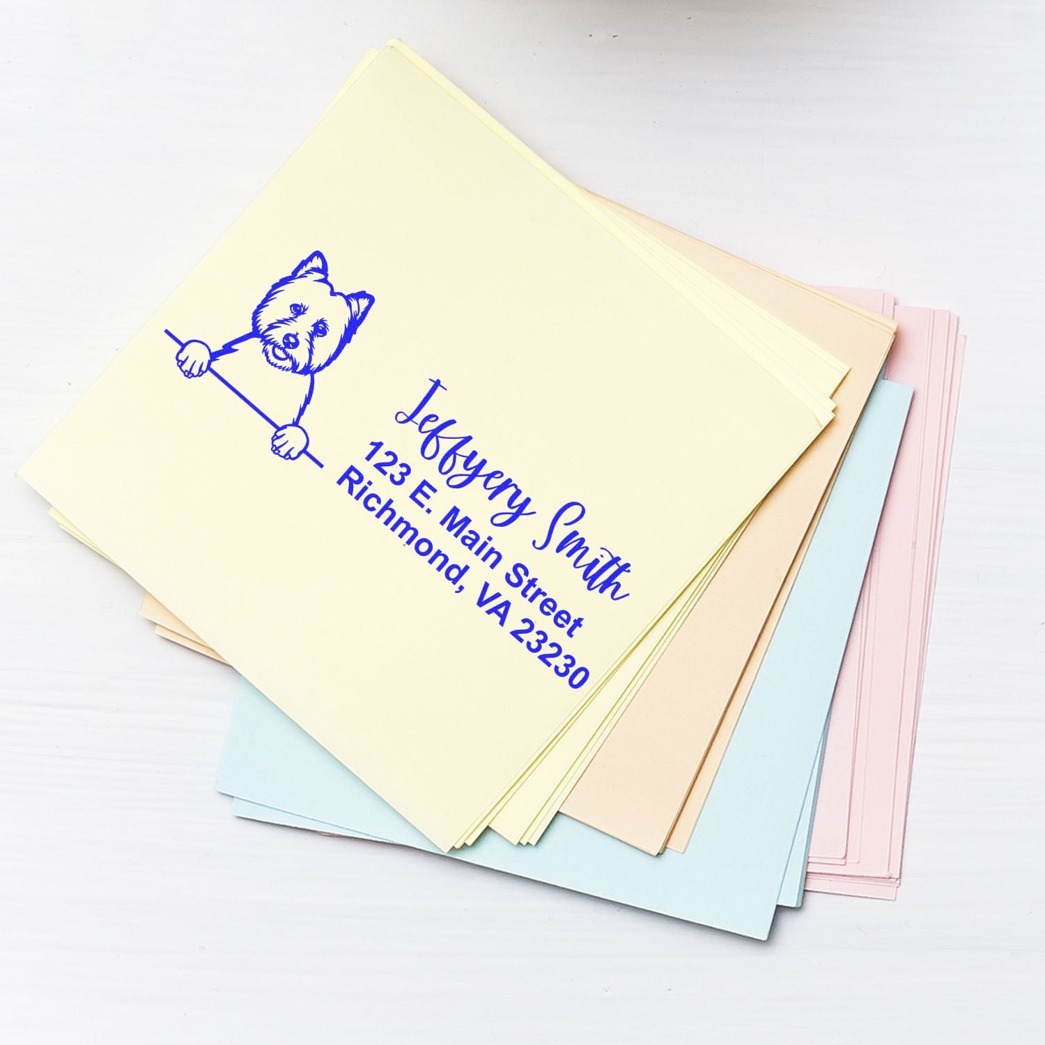 Custom address rubber stamp with dog logo on pastel stationery for personalized envelopes.