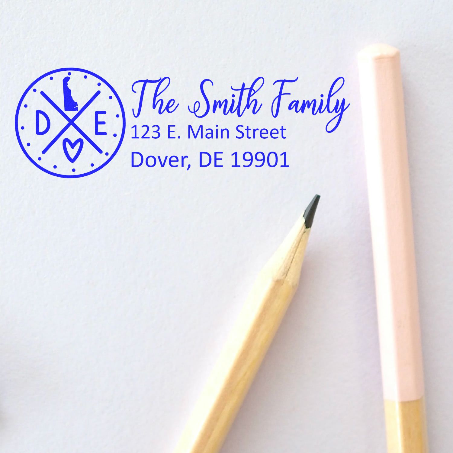 Personalized family return address rubber stamp with monogram logo, The Smith Family, Dover, DE 19901, shown in blue ink.