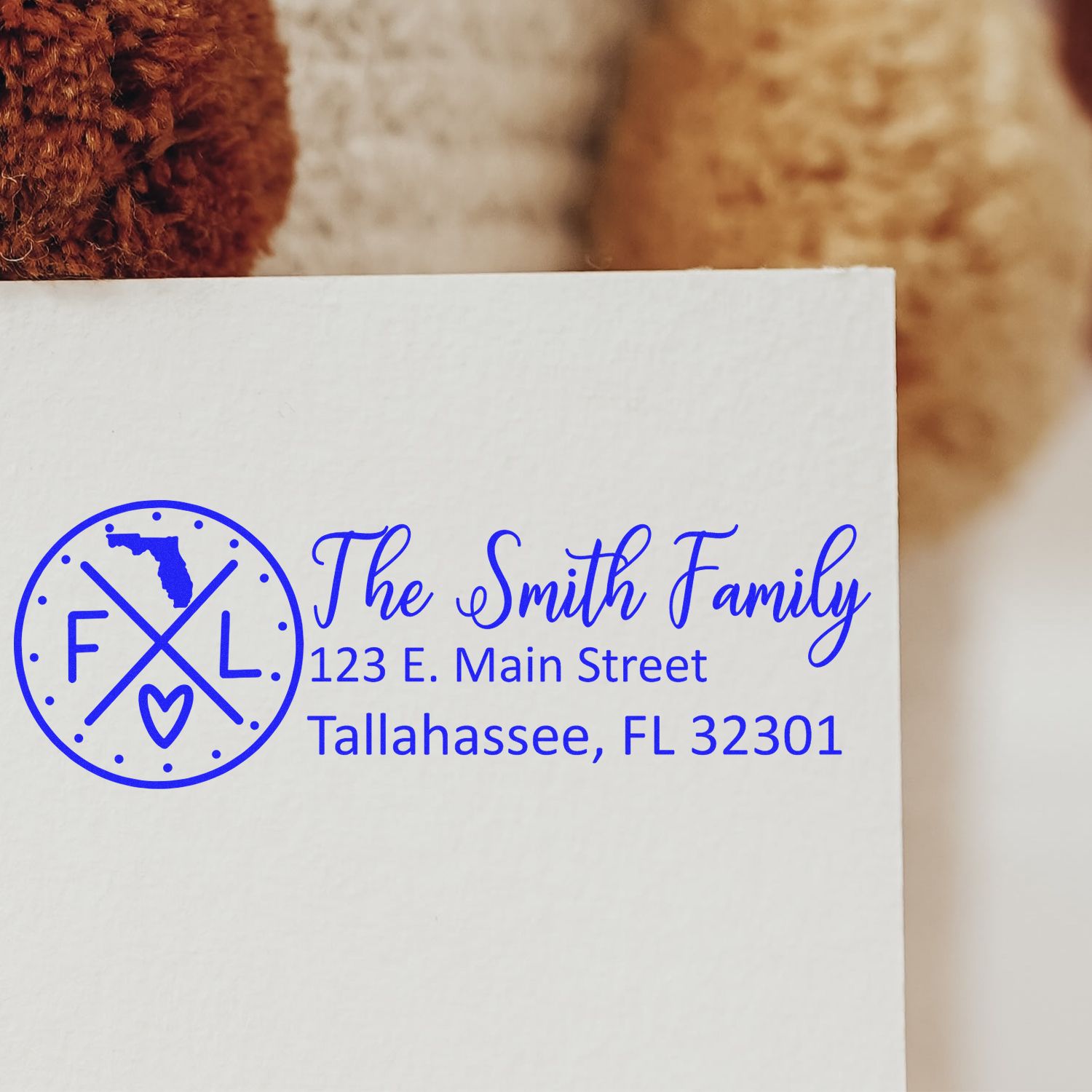 Personalized family return address rubber stamp with monogram logo and Tallahassee, FL address in blue ink.
