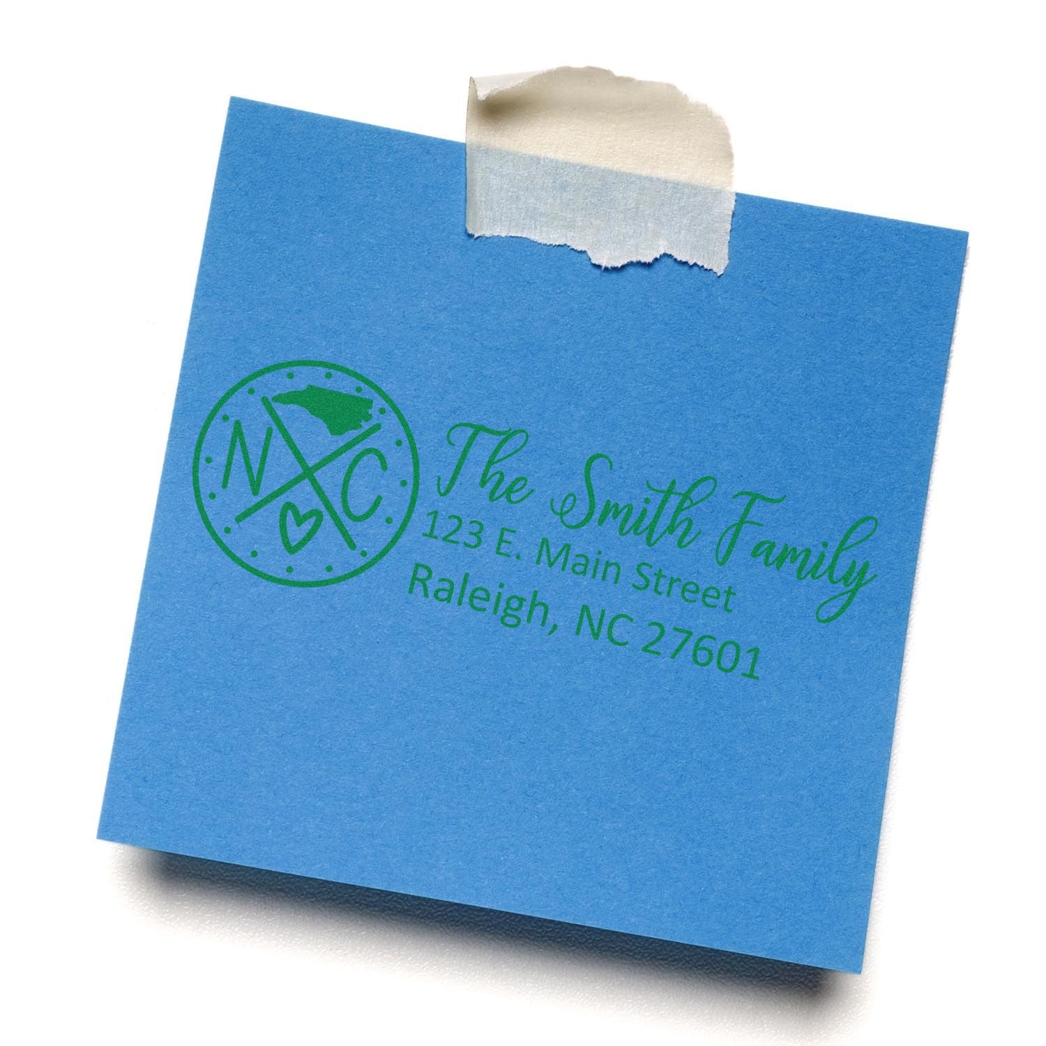 Personalized return address rubber stamp on blue envelope with family name, monogram logo, and Raleigh, NC address.