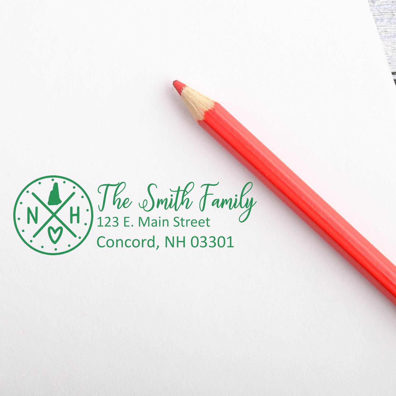 Custom family return address rubber stamp impression with monogram, styled beside a red pencil.