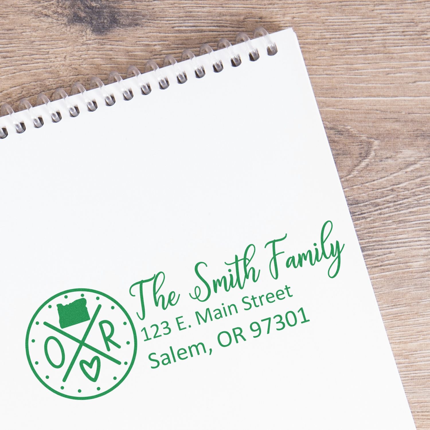 Custom family return address rubber stamp with monogram, name, and Salem, OR address on a notebook page.