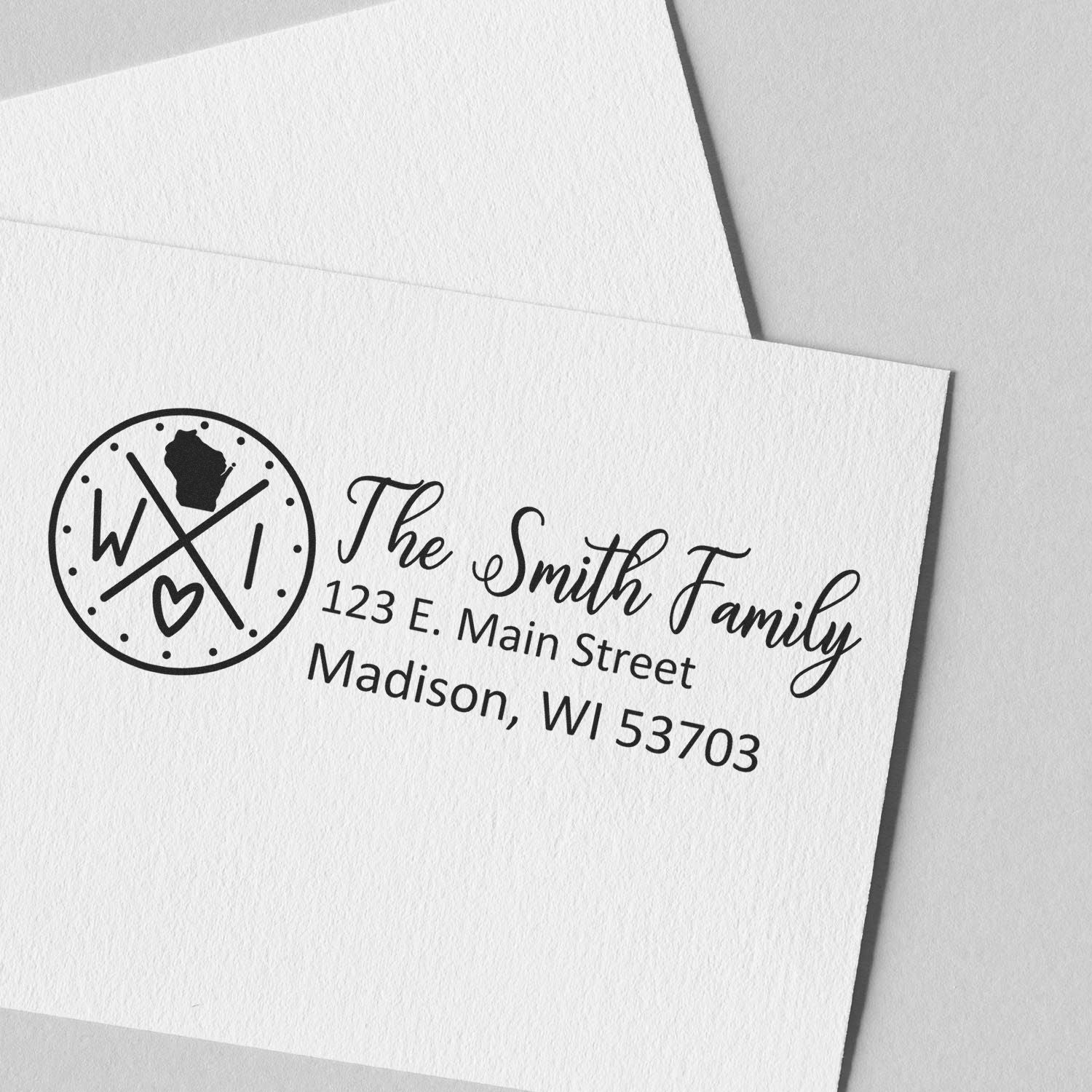 Custom return address rubber stamp for The Smith Family, featuring monogram logo and Madison, WI address on white envelope.