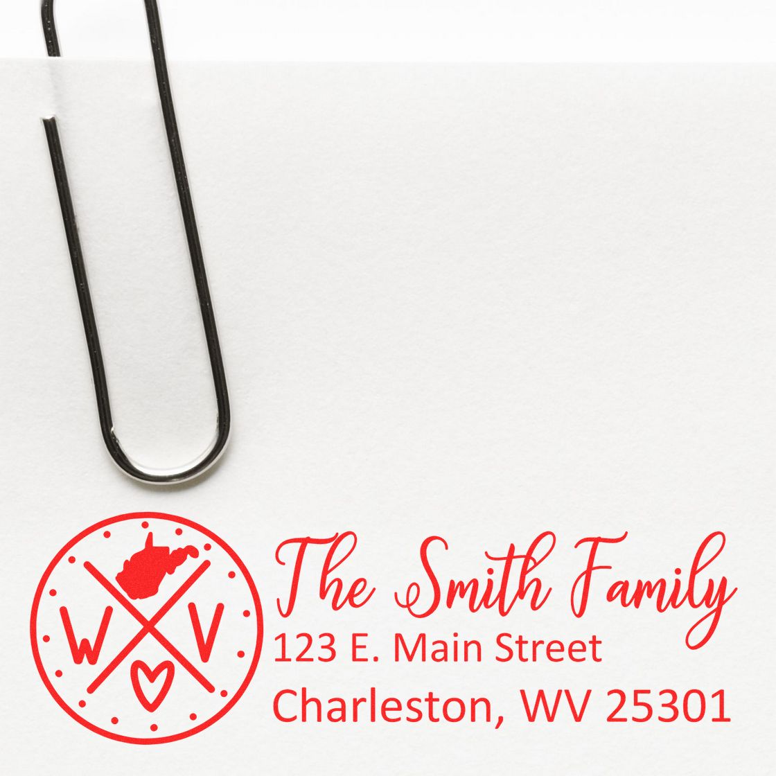 Custom rubber return address stamp with The Smith Family name and Charleston, WV address in a red monogram design.