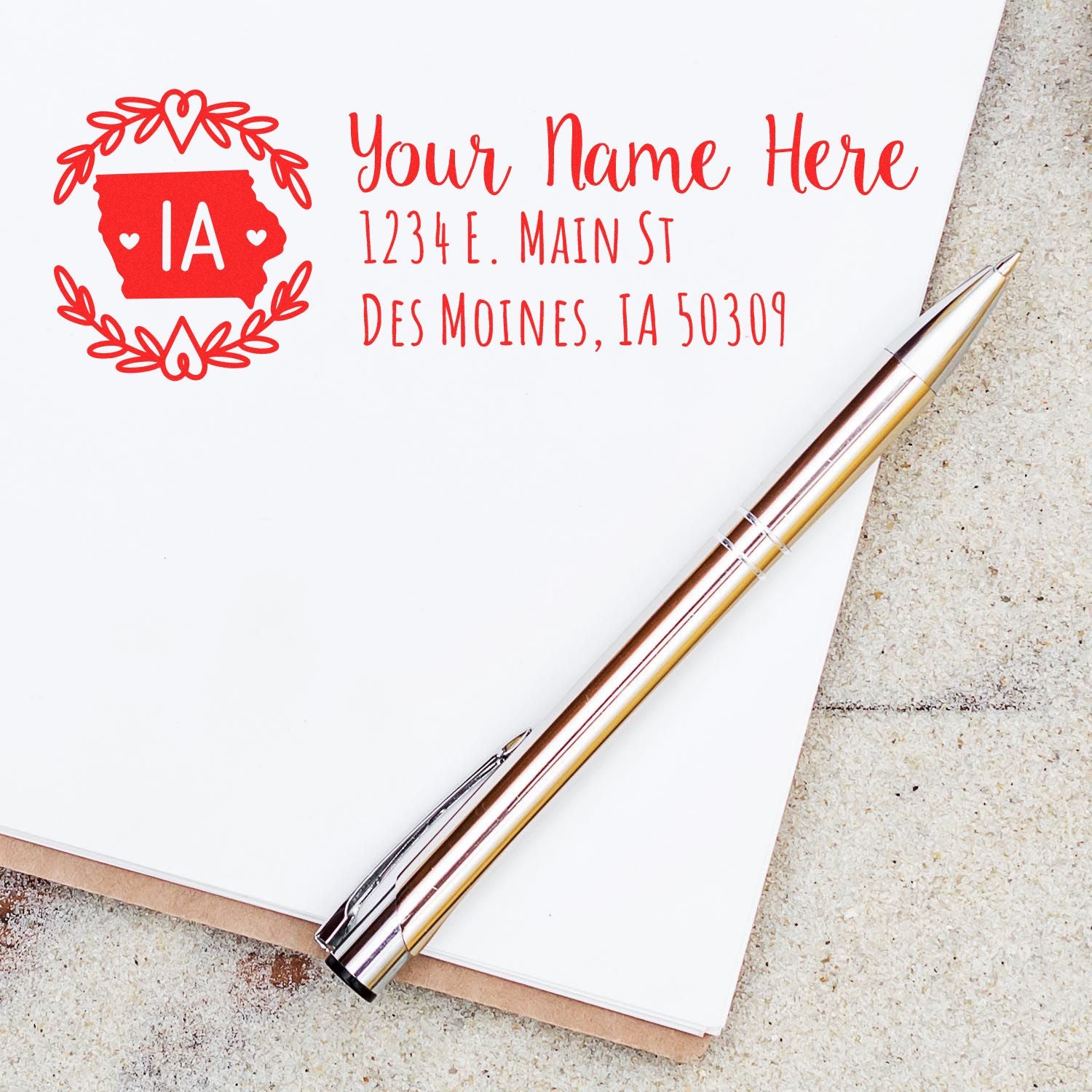 Custom Iowa address rubber stamp with personalized name and mailing address in red ink on stationery.