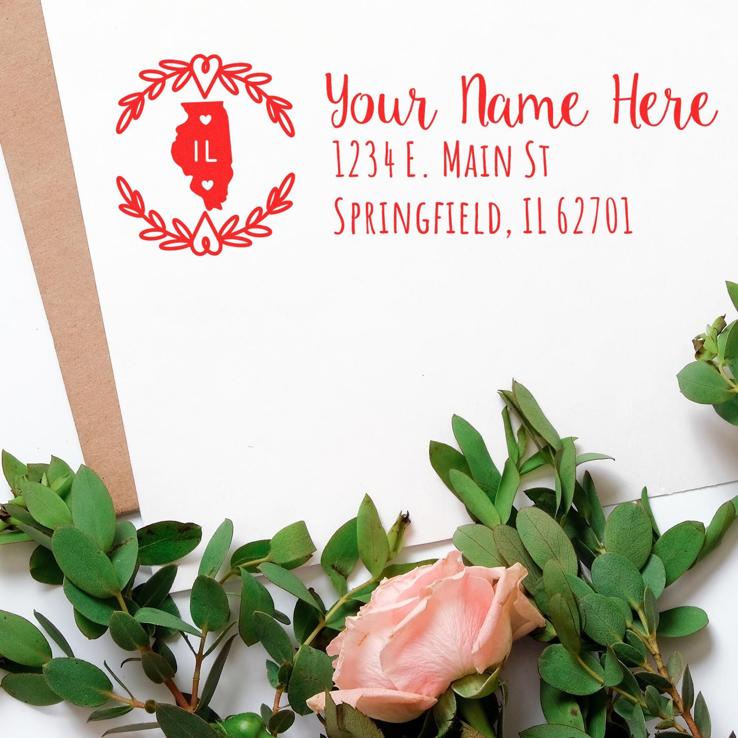 Personalized Illinois return address rubber stamp in red ink with floral wreath, custom name, and address for envelopes.