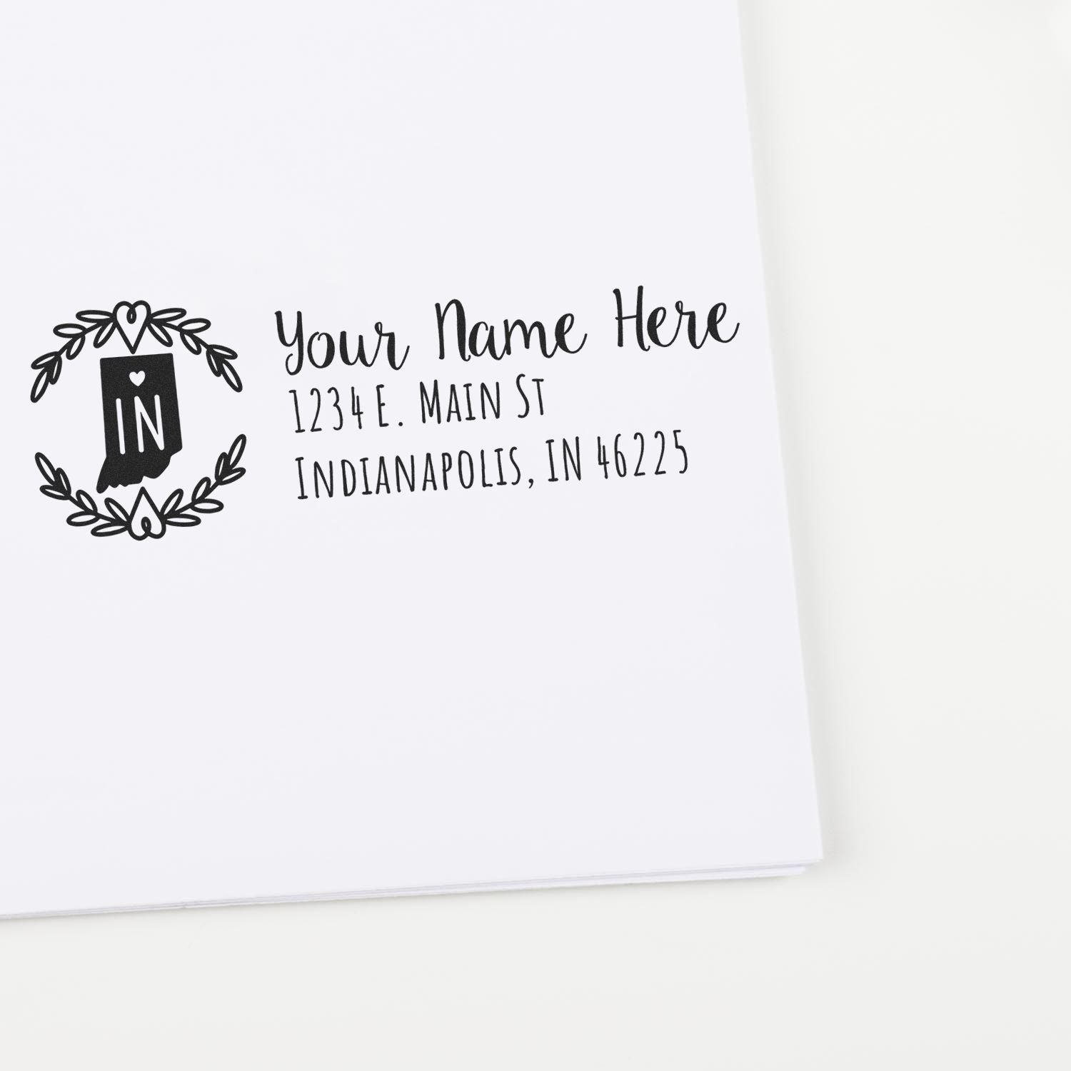 Custom return address rubber stamp with Indiana state design and personalized name, street, and city address on paper.