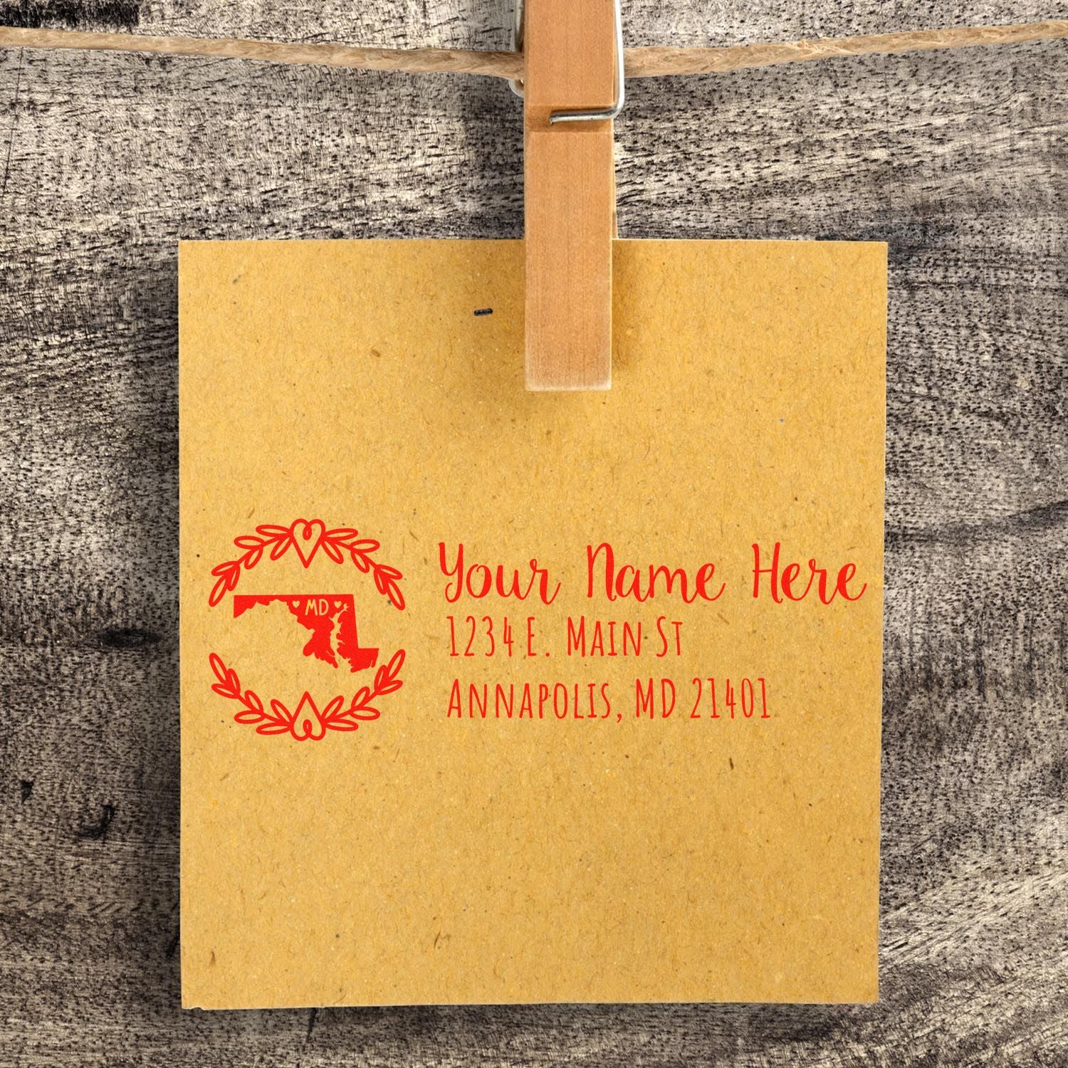 Custom rubber return address stamp with Maryland map design, showing a red name and Annapolis, MD address on kraft paper.