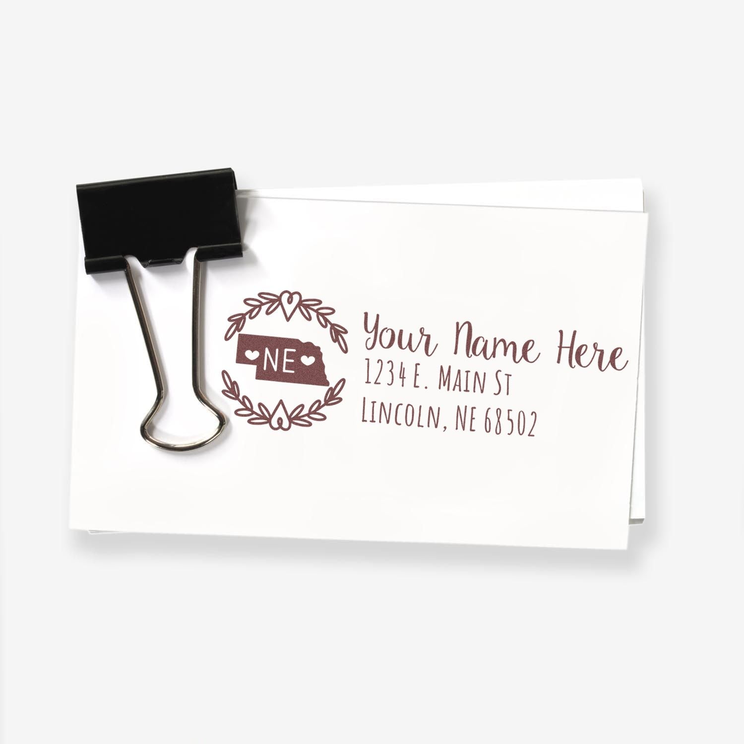 Custom return address rubber stamp with Nebraska state design, personalized name, street address, and ZIP code on stationery.